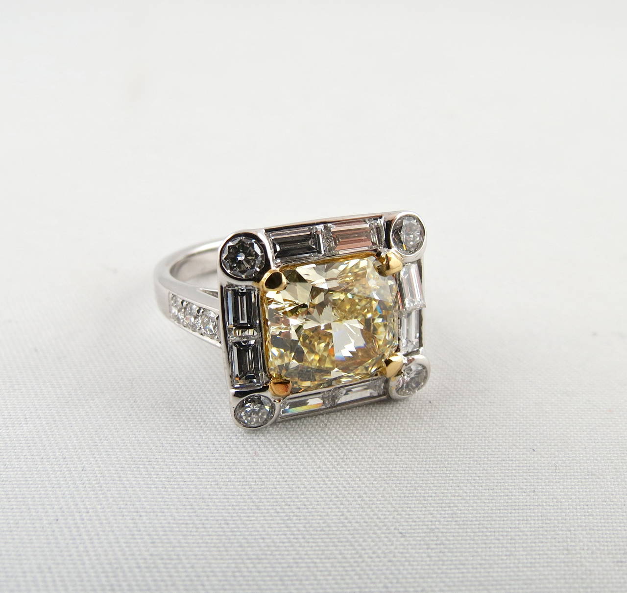 Magnificent diamond ring, centering on a natural fancy yellow diamond weighing 4.01 carats, two diamond baguettes per side around the central diamond, 4 brillant cut diamonds in the corners, mounted in 18k white gold and yellow gold setting.