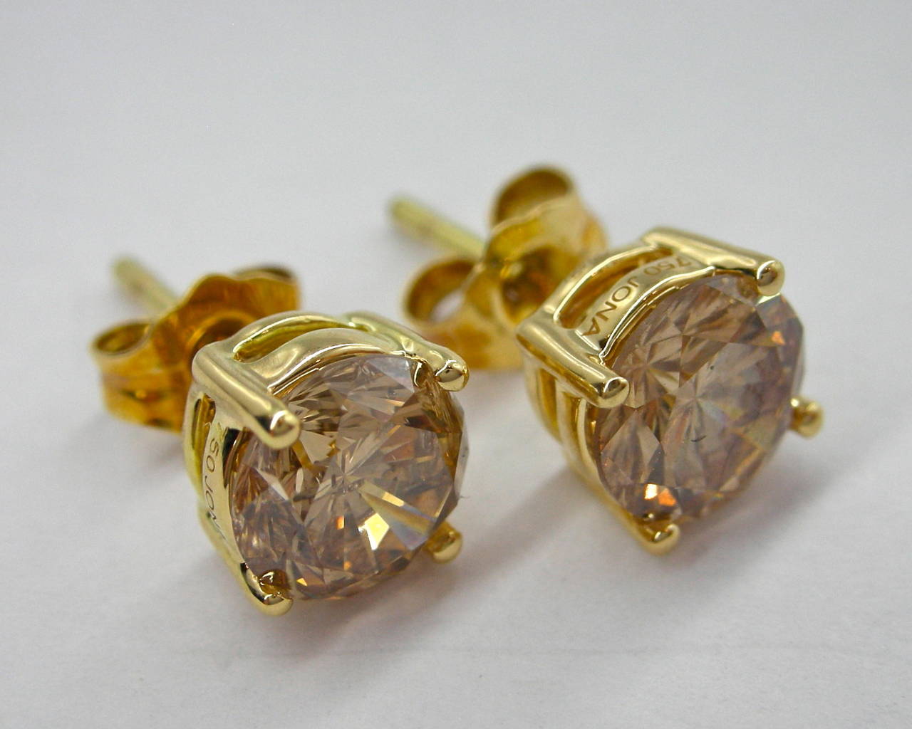 Jona, 18 karat yellow gold, round brilliant cut brown diamond stud earrings, showcasing a pair of brilliant cut brown diamonds weighing 1.04 and 1.06 .

All of our jewelry is new and has never been previously owned or worn.