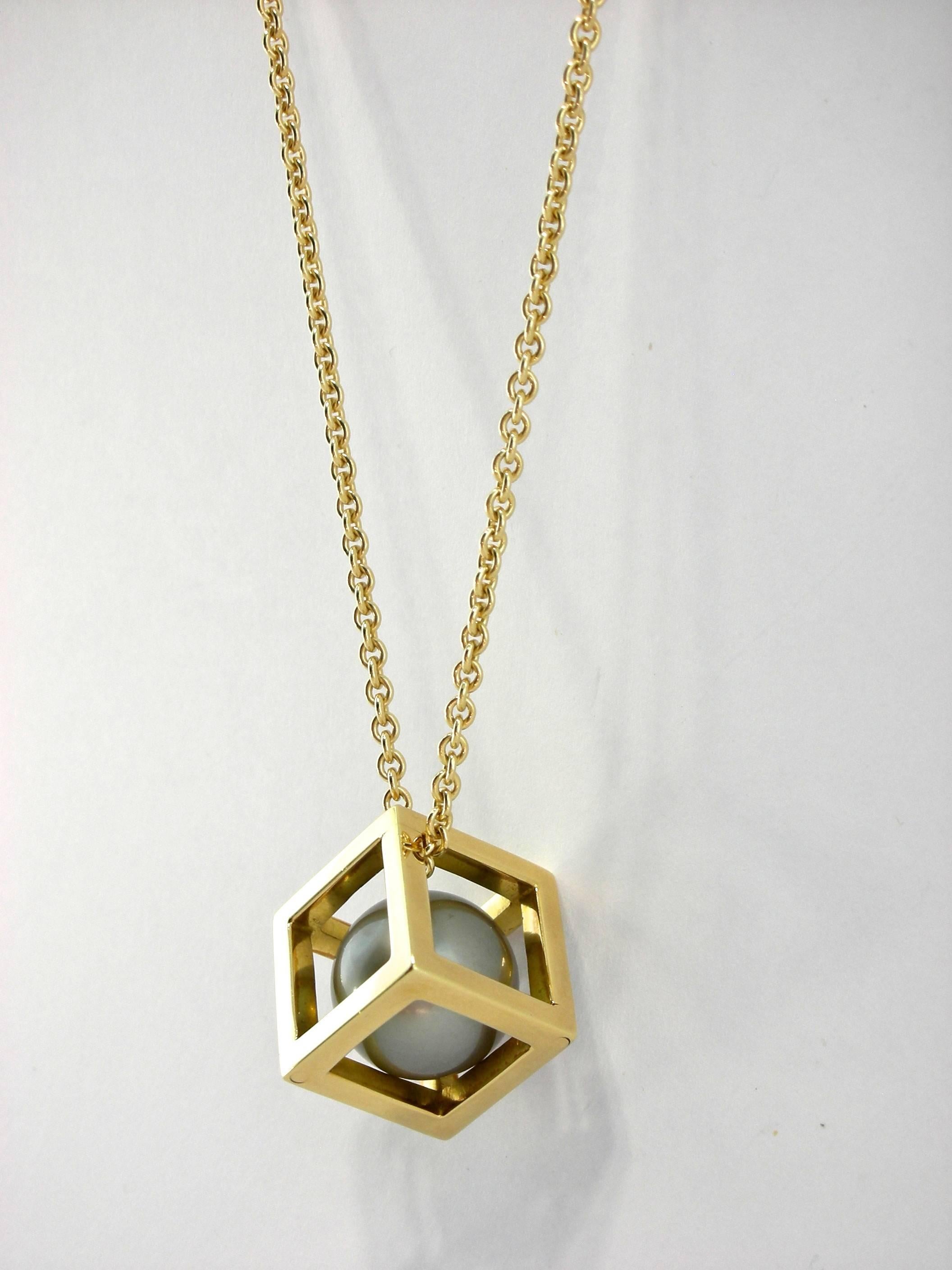 Jona design collection, hand crafted in Italy, 18 Karat yellow gold cube pendant, weighing 5.80 gr. and measuring 13.40mmx13.40mm, enclosing a 12mm Tahiti grey pearl weighing 25 carats, with a 39cm long chain necklace weighing 5.70 grams.

All of