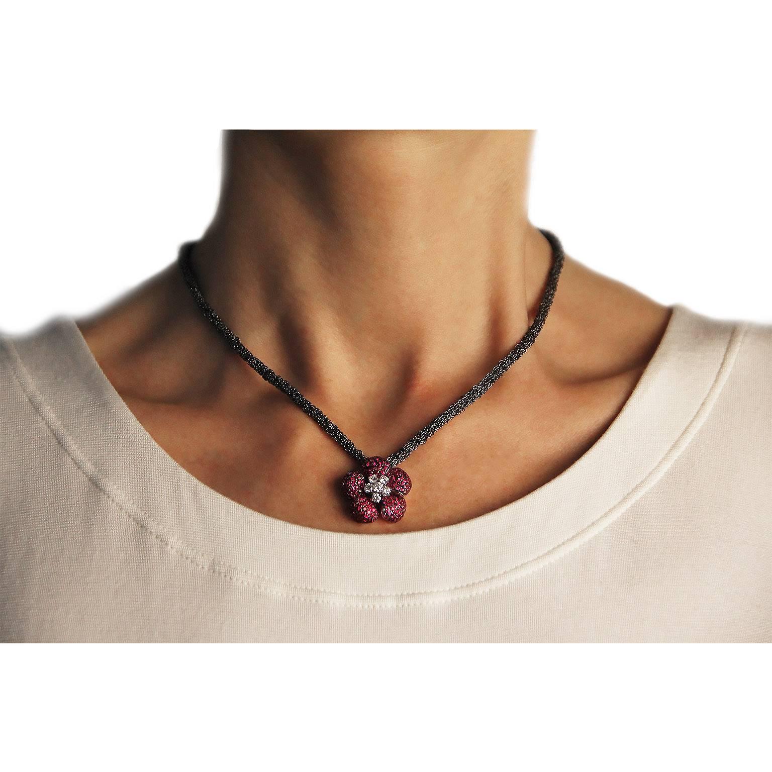 Jona design collection, hand crafted in Italy, 18 karat white gold flower pendant set with 211 rubies weighing 3.56 carats and 6 diamonds weighing 0.61 carats in total, G color, VVS2 clarity, on a woven burnished sterling silver chain necklace, 17.7