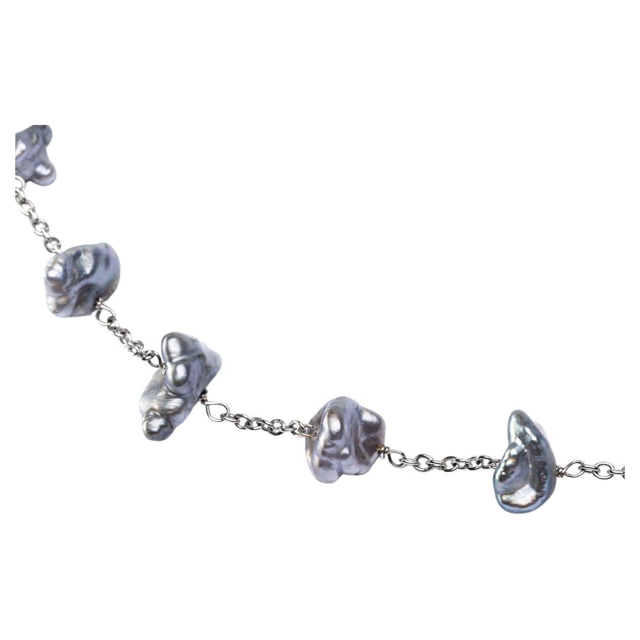 Collection design Alex Jona, travail artisanal en Italie, or blanc 18 carats, collier sautoir de 51.18 in /130 cm de long avec 59 perles de Tahiti gris clair keshi.

Les bijoux Alex Jona se distinguent non seulement par leur design particulier et