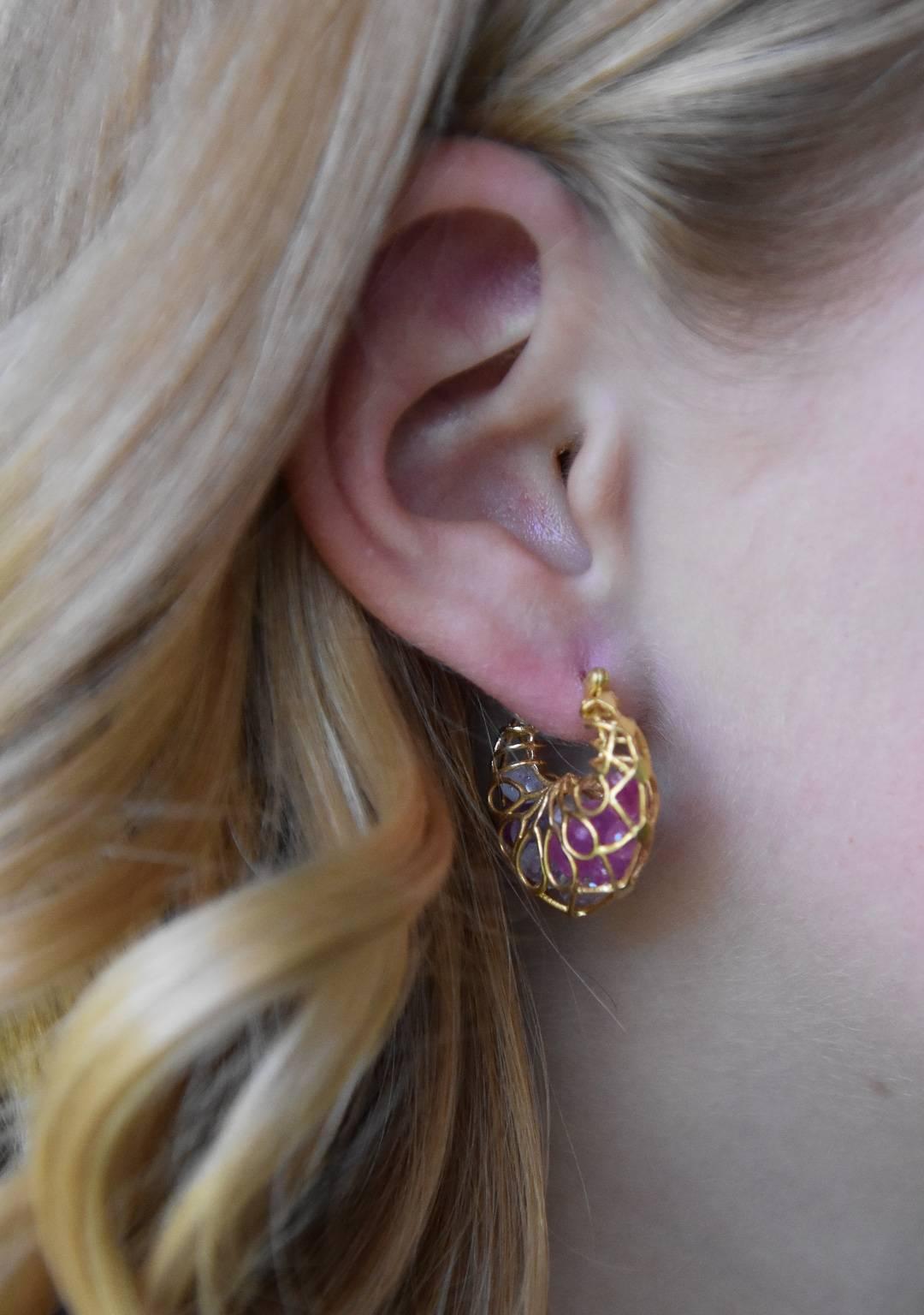 Fun and flirty, these gold hoops are as unique as they come!  Loose pear shaped pink sapphires dance around inside this matte gold hoop cage.  Light enough for all day wear, and can go casual or dressy.  Perfect finishing touch on any outfit. 