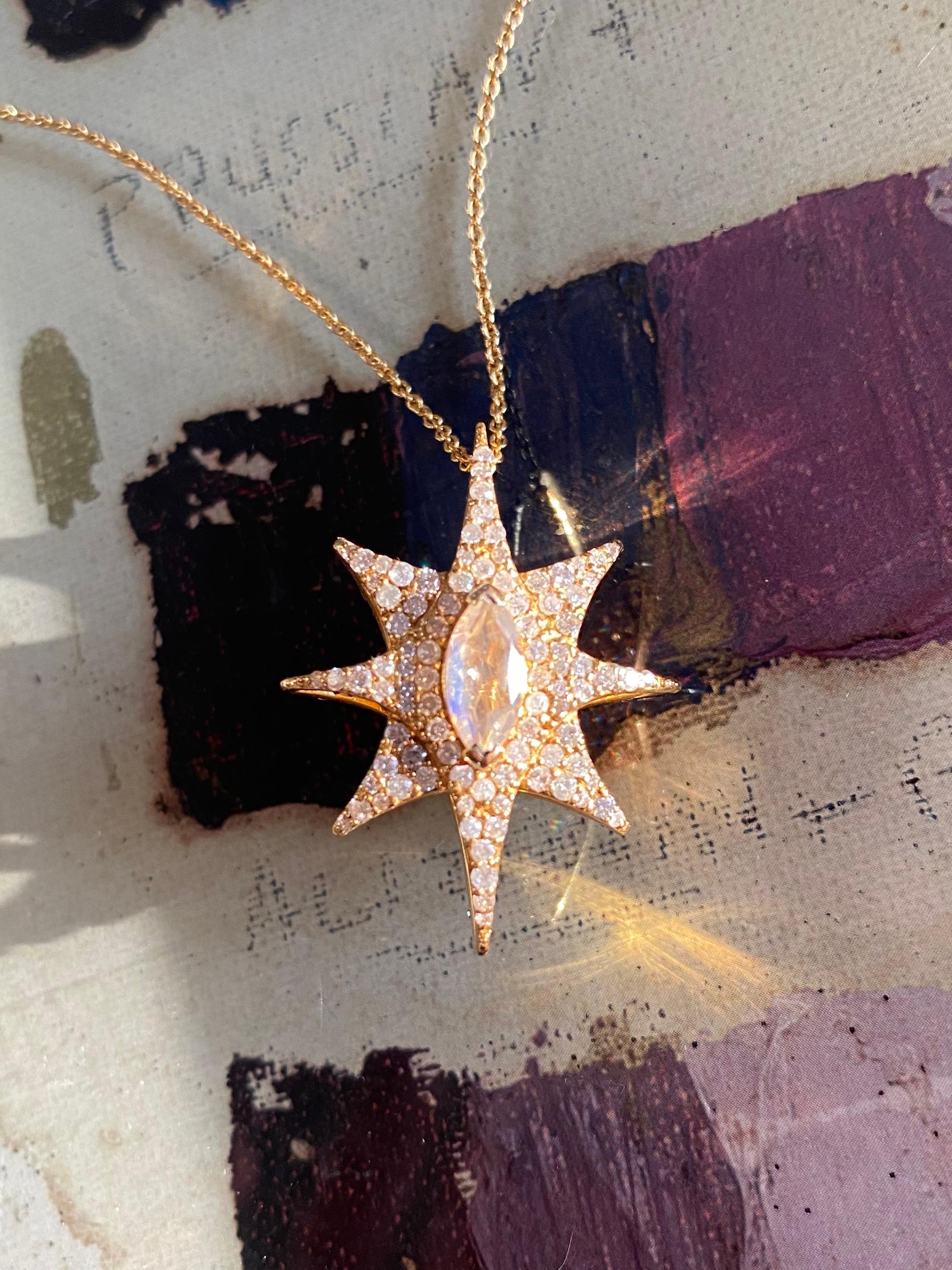 This double-sided star pendant boasts 1.60 carats of diamonds, with white diamonds on one side, and a surprise of green diamonds on the other side.  Each side has a beautiful rainbow moonstone marquis stone in the center of the starburst.  The total