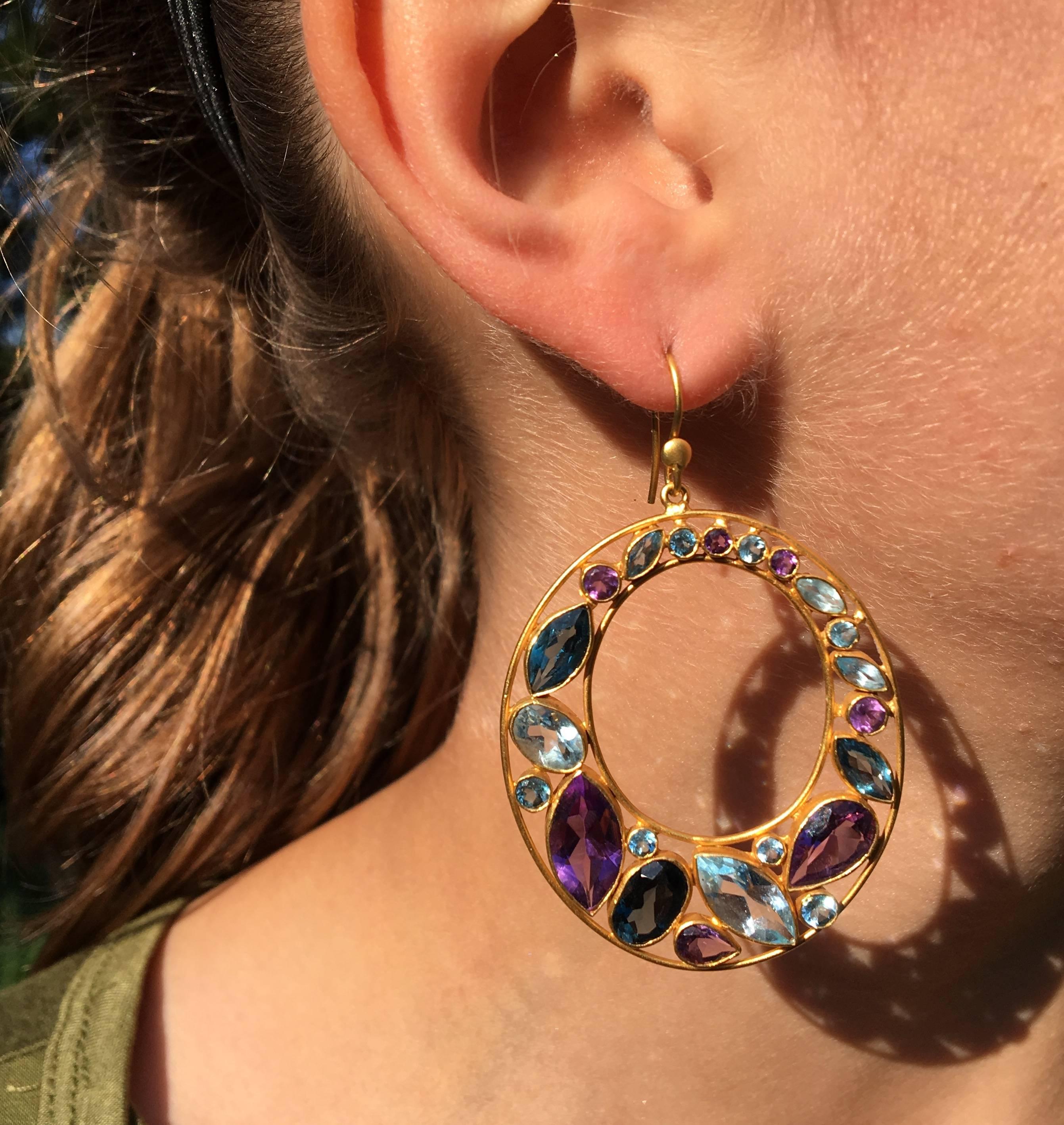Colorful and bold, these earrings are a really stunning addition to any jewelry wardrobe!  These 18kt Gold earrings feature beautiful Amethyst, deep blue London Blue Topaz, and vibrant Aquamarines, all set in an open oval setting that is flattering