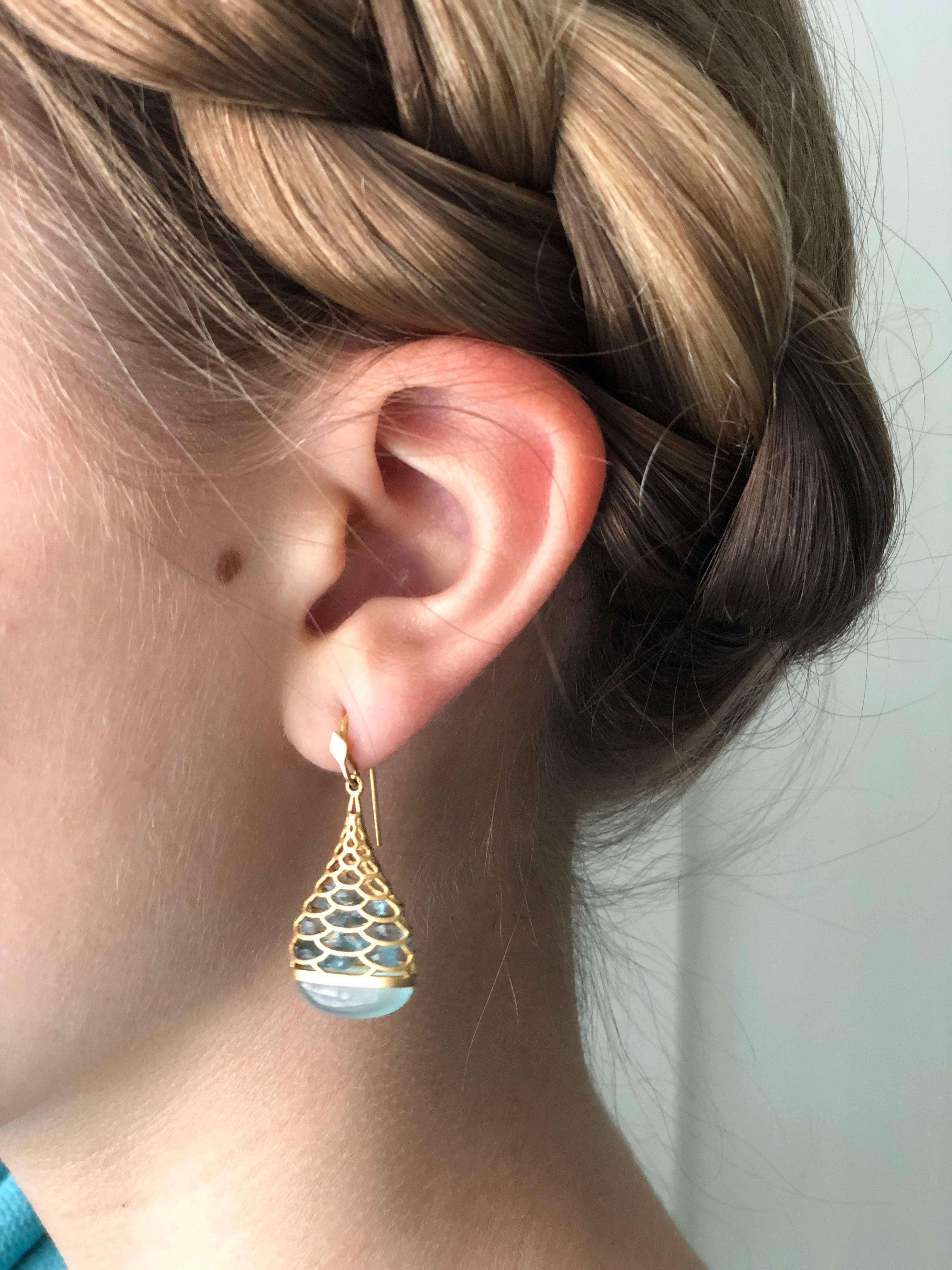 Faceted Aquamarines float inside these 18kt yellow gold teardrop shaped caged earrings, catching the light in a playful and unique mermaid pattern, with a cabachon Chalcedony set at the bottom. Finished in Lauren Harper's signature matte gold