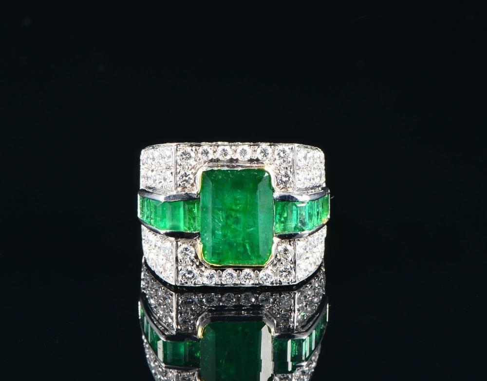 A striking Art Deco Style inspired large sized ring, completely hand created of solid 18 KT gold - marked.

Italian origin.

Geometric forms give life to a sophisticate combination between Natural Emerald and Diamonds; completed with French cut