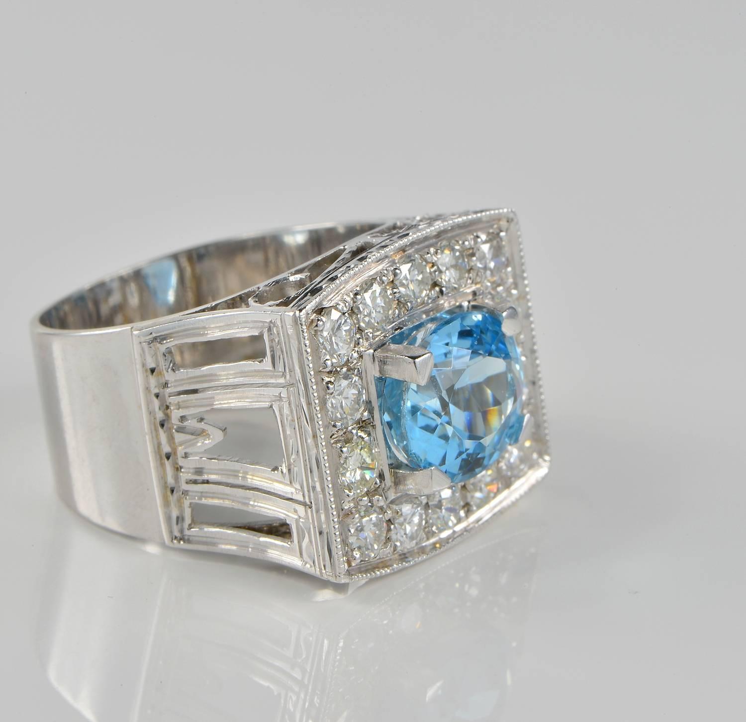Superb retro ring of highly detailed past workmanship, boasting natural Aquamarine of 3.0 Ct intense deep sky blue full of inner life and great sparkle.
Further bordered by 1.10 Ct of quality round brilliant cut Diamonds rated as G VVS/VS
It has