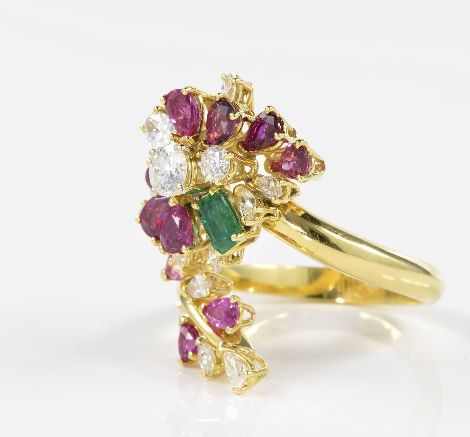Exquisitely hand crafted as a statement cocktail ring. 
Set throughout with vivid Burmese Rubies of 2.50 Ct enriching with colourful impact the charming floral design coiling around the finger. 1.23 Ct Diamonds F/G VS/SI and some champagne colour