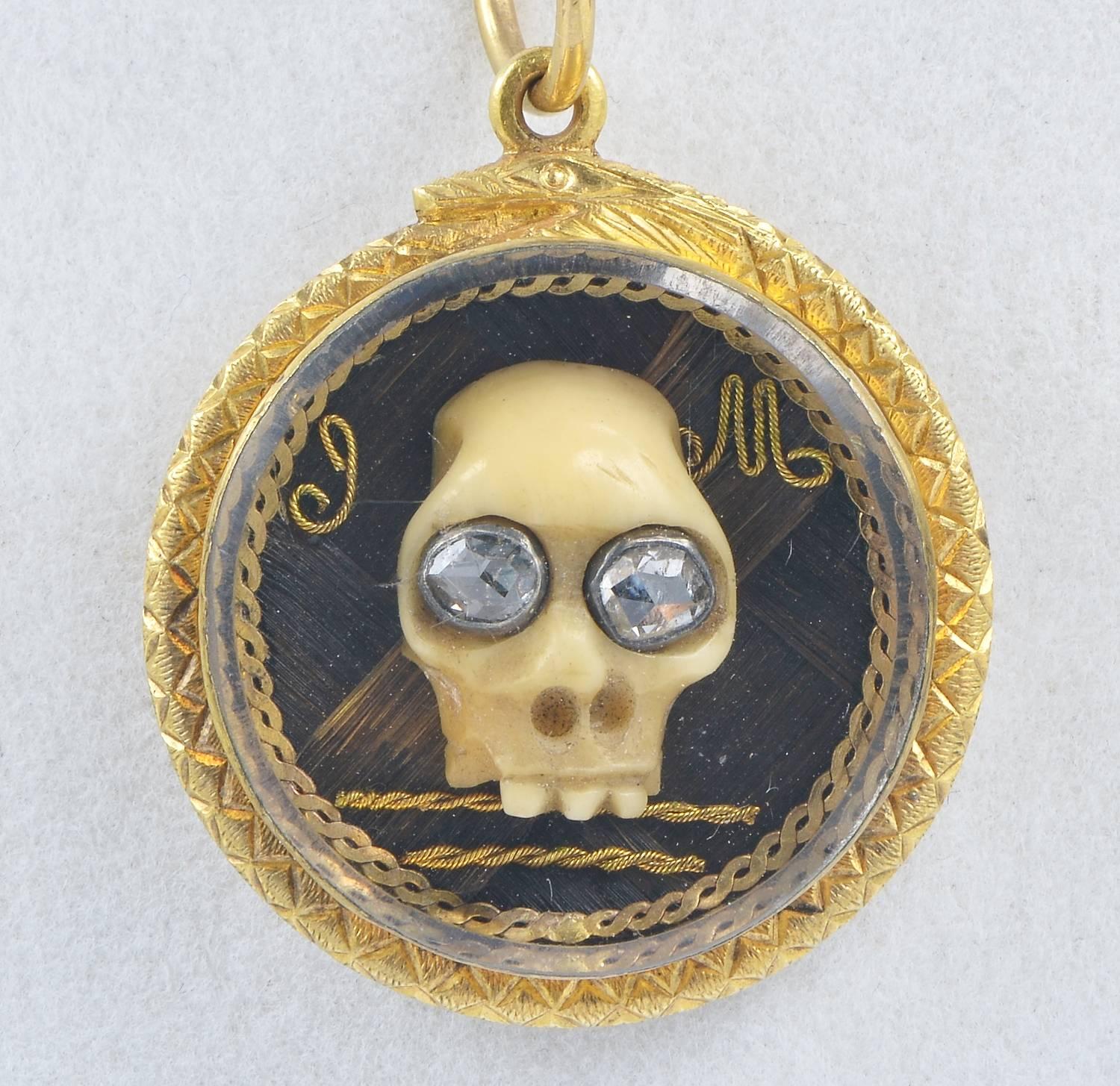 rare 22 KT solid gold pendant of the Georgian period 
a Memento Mori Skull with Diamond eyes is kept under a rare Stuart Crystal
Close back setting beautiful detailed with a snake biting its tail in sign of eternity
artwork hair in the inside with