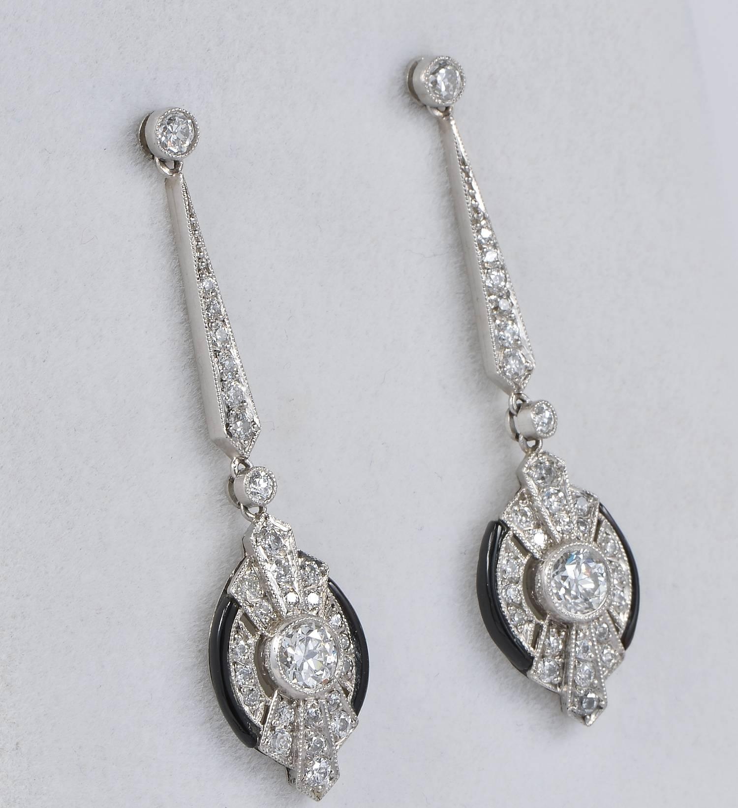 Sleek, sophisticate Art Deco pair of drop earrings crafted of solid Platinum.
Fine design rendered in Black Onyx and Diamond sparkle.
Boasting 3.0 full carat of Diamonds in all with two large 1.20 Ct old European cut Diamond set in the middle (rated