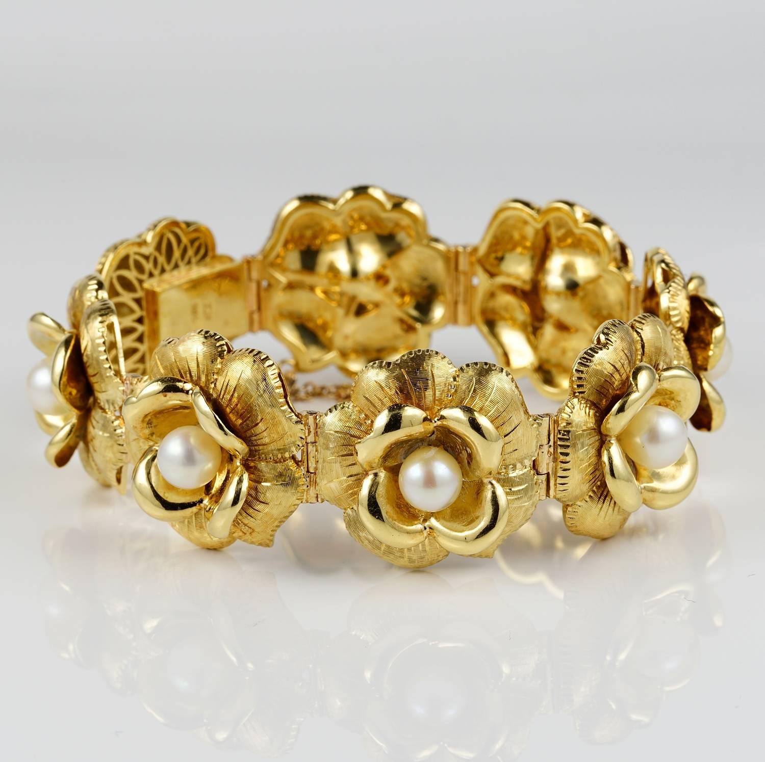 A very femminine and charmng 1940 ca 18 KT solid gold bracelet, bearing Italian post II World War marks
Exquisietly styled in an array of gold flowers, detailed with satin, carving and polished details, with lovely heart of pearls adding an extra