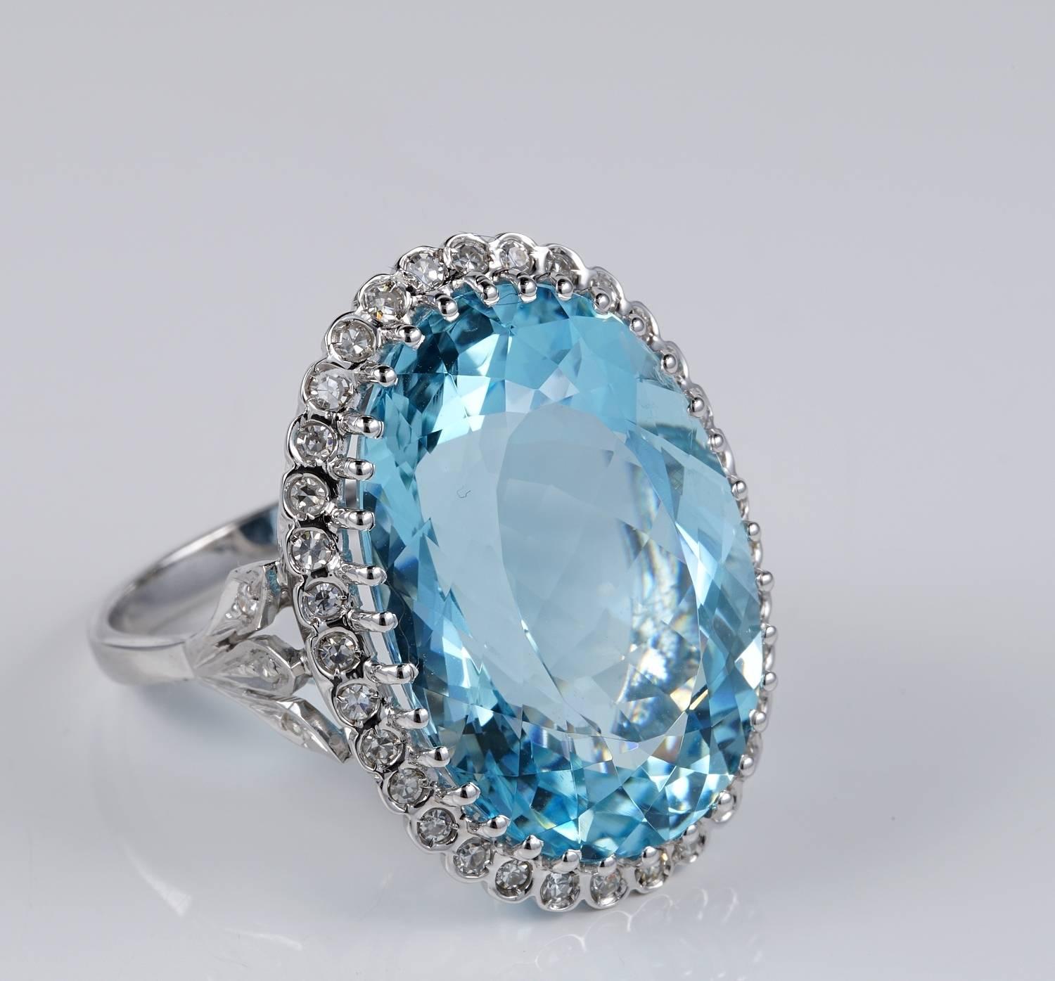 Jumbo sized Natural Aquamarine & Diamond vintage ring dating back to 1950 ca
Stunning cluster ring boasting a 100% Natural Aquamarine of bright and lively intense sky blue hue finely oval faceted 27.0 Carat in weight
Complemented by a garland of .70