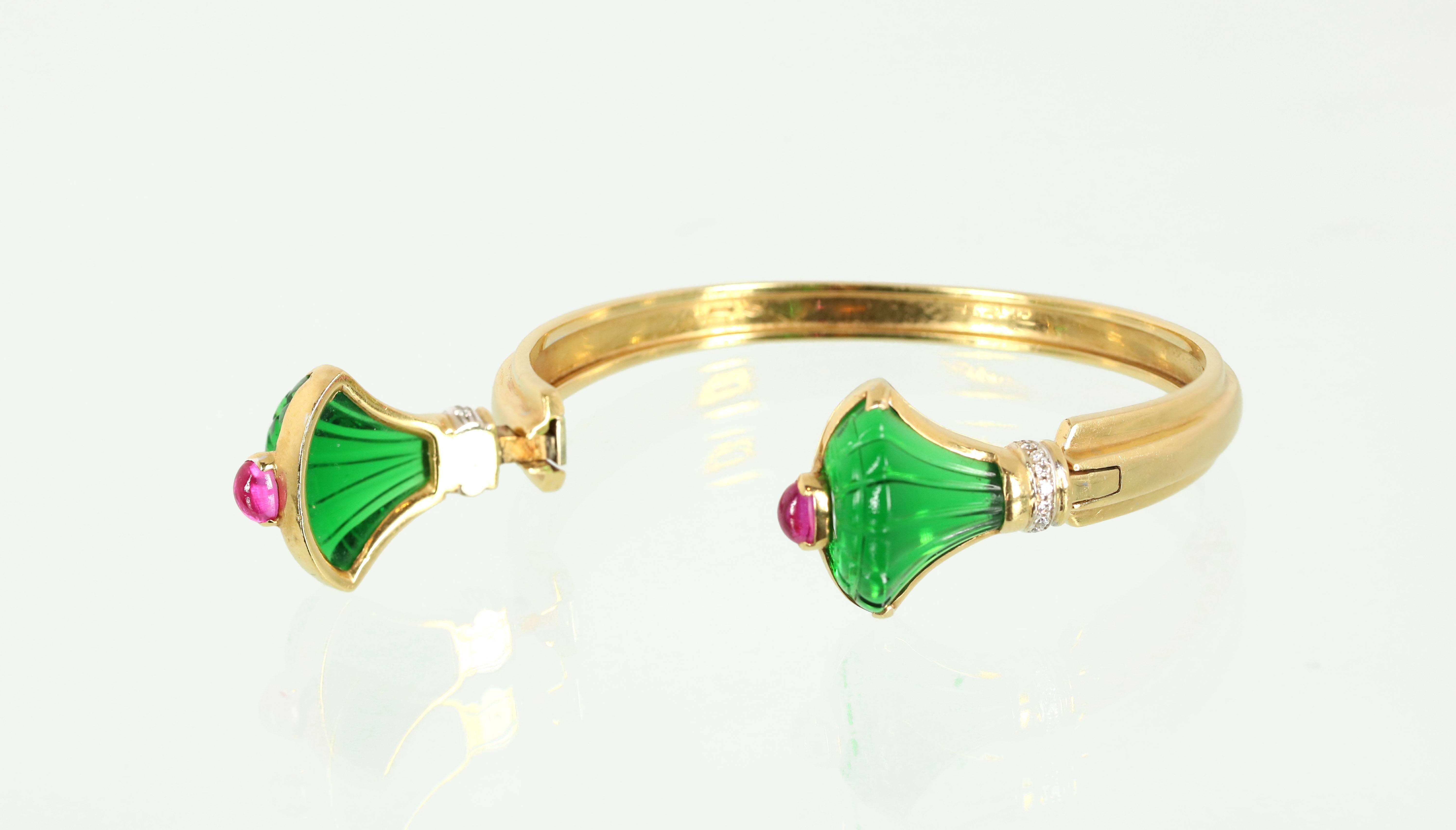 A very stylish emerald-color carved glass, ruby cabochon and diamond bangle bracelet. 18K yellow gold