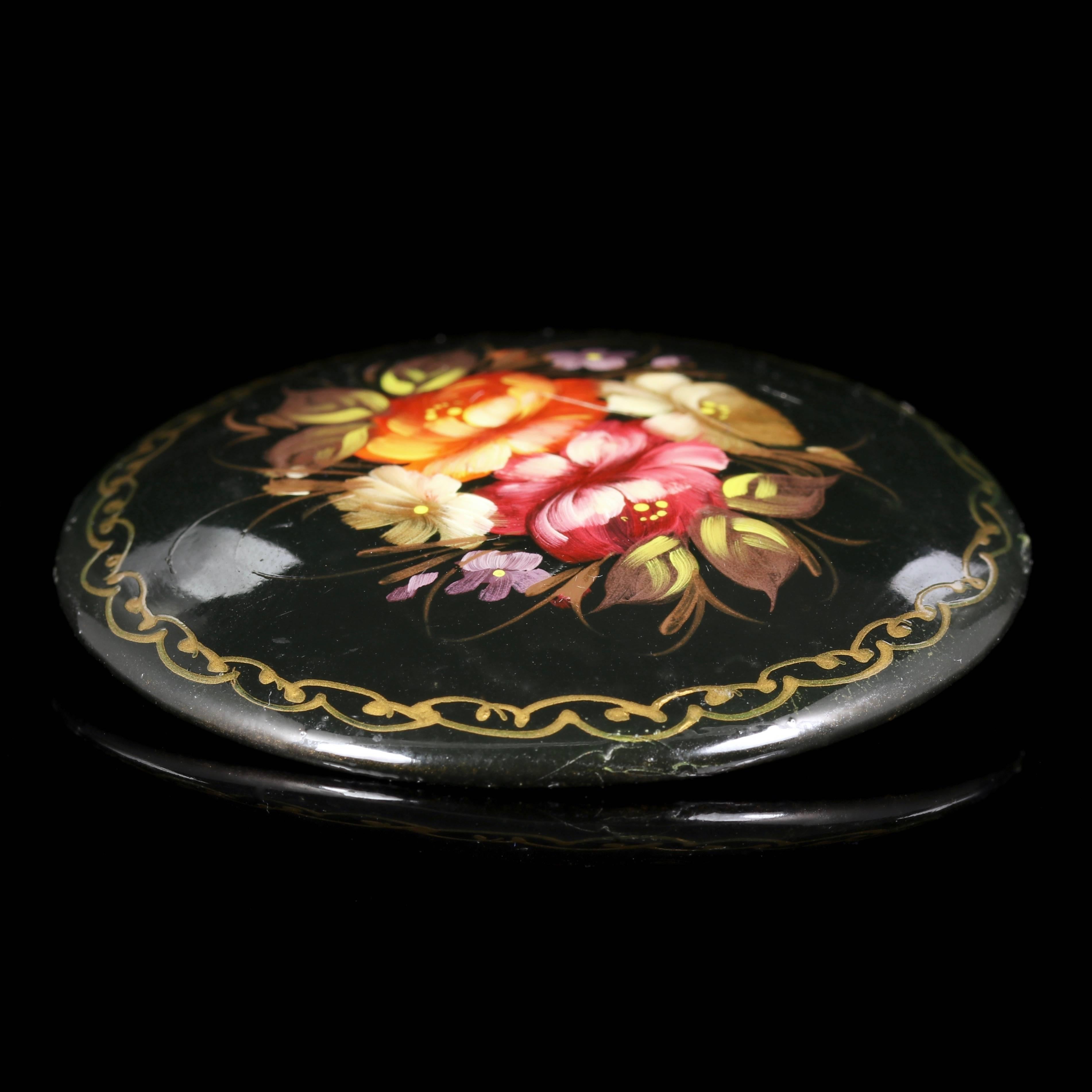 A fabulous Russian hand painted floral brooch that has a signature on the reverse.

This brooch has a very pretty floral design on the front which is hand painted and shines with vibrant colours.

Papier-mâché is a composite material consisting of
