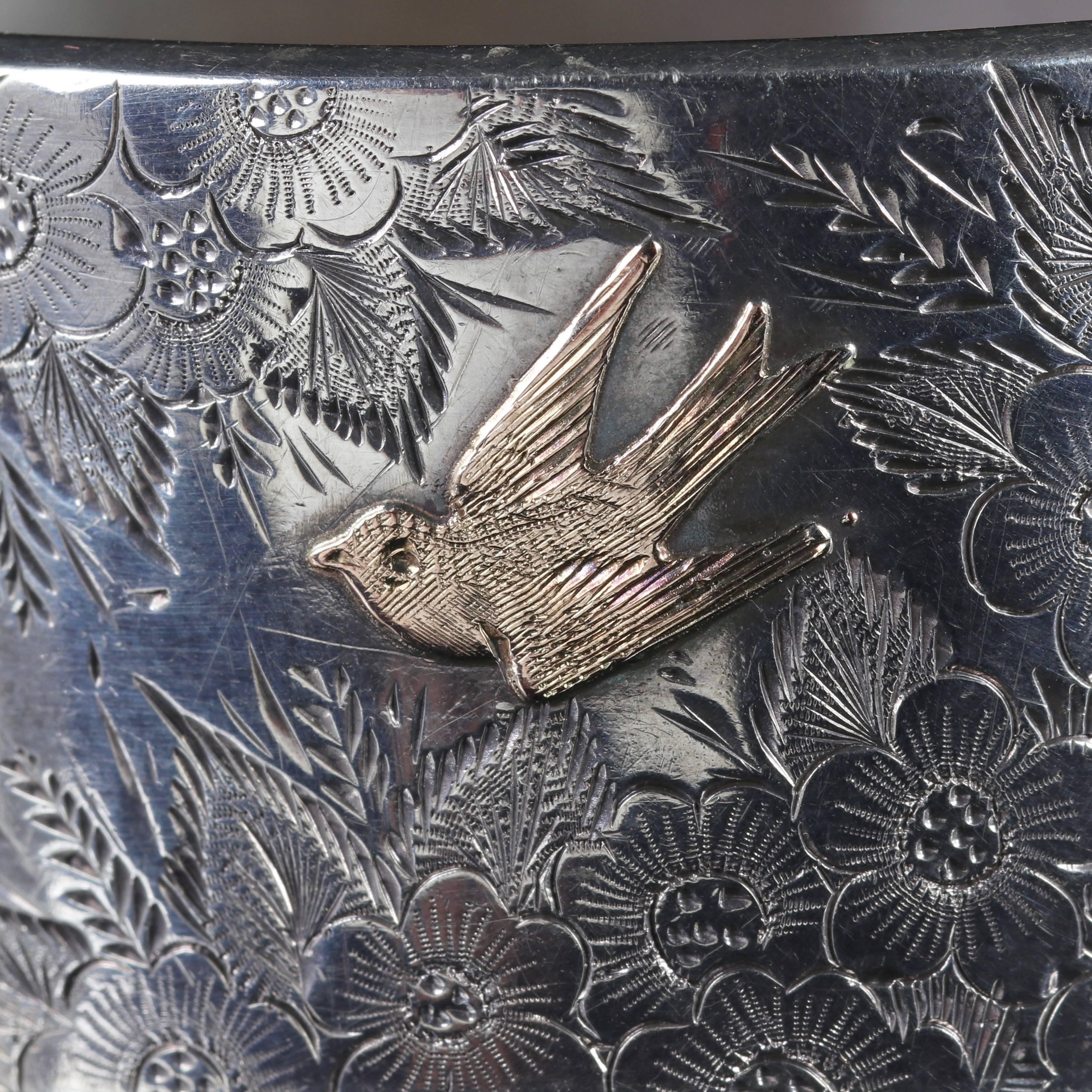 This fabulous Sterling Silver and Gold Victorian bangle is Circa 1900.

Displaying Gold workmanship on the top gallery of a bird and butterfly in flight.

The top of the gallery is engraved with forget me nots and ivy. 

-Forget-me-not, O Lord!- is