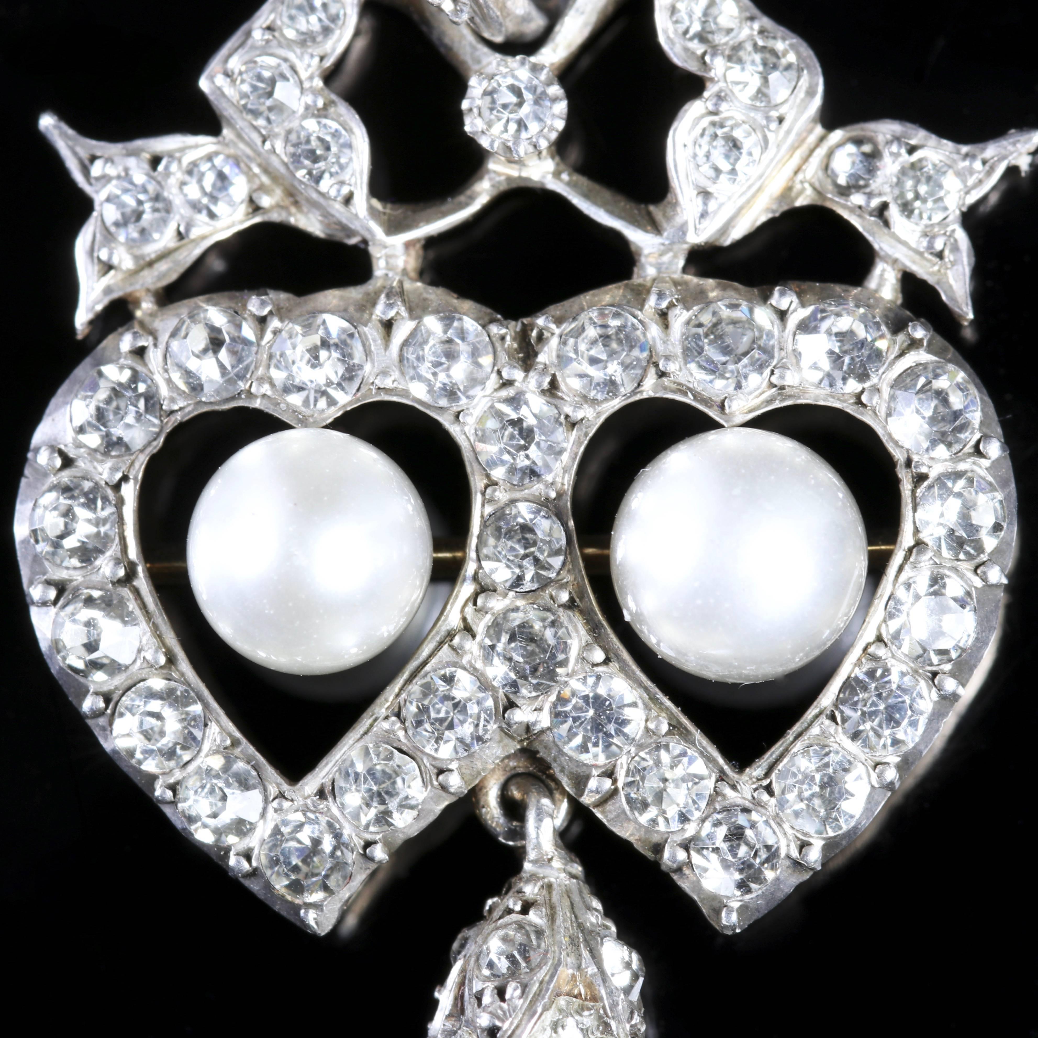 This fabulous Sterling Silver Edwardian pendant is set with Pearls in two intertwined hearts.

The intertwined hearts are a sign of love and devotion.

The pendant is decorated with beautiful white Paste Stones with two central Pearls and an elegant