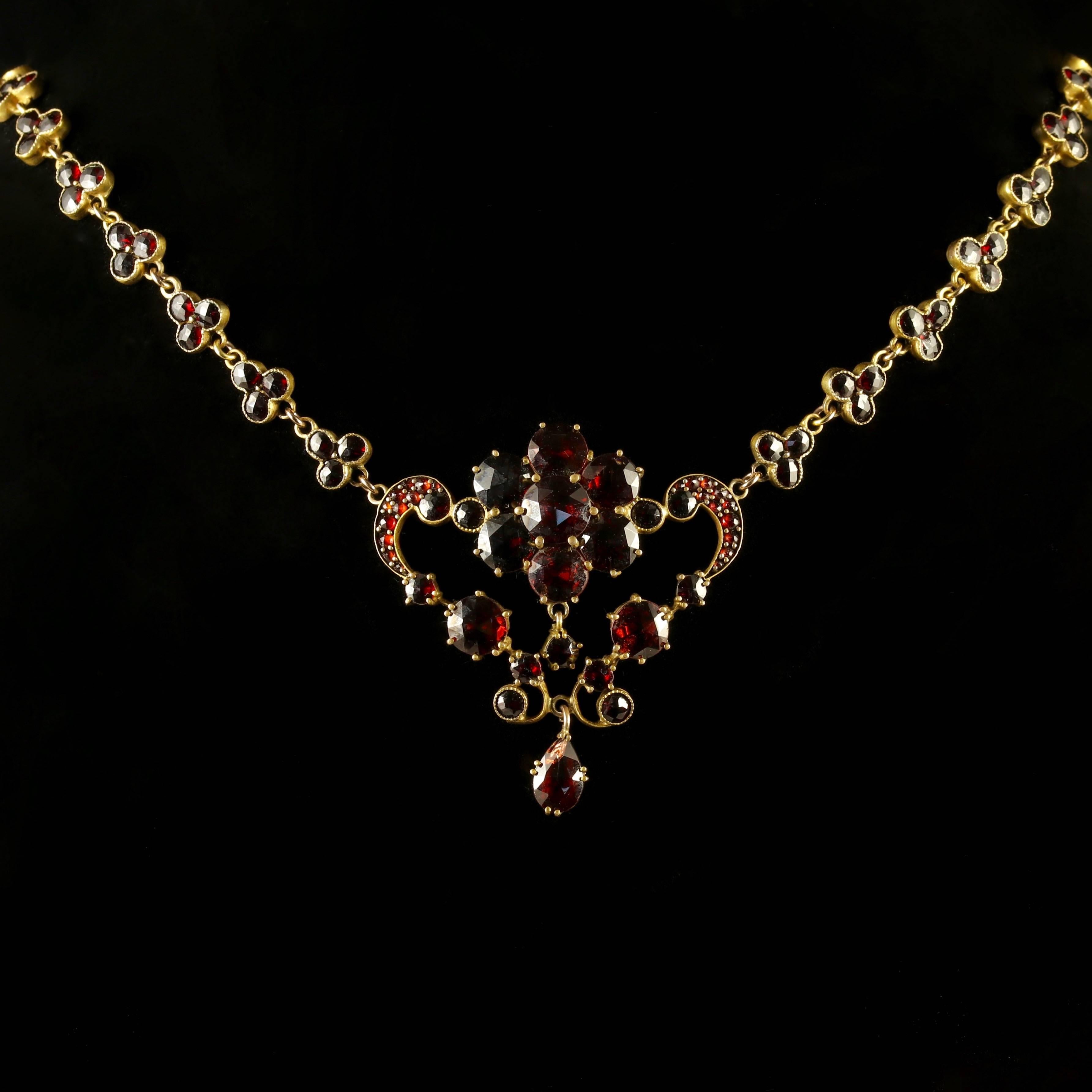 This spectacular Victorian necklace is set in Garnet Gold and adorned with deep red Garnets. 

Genuine Victorian, Circa 1880. 

The Garnet encrusted chain leads to a beautiful floral pendant, the central flower alone has over 7ct worth of