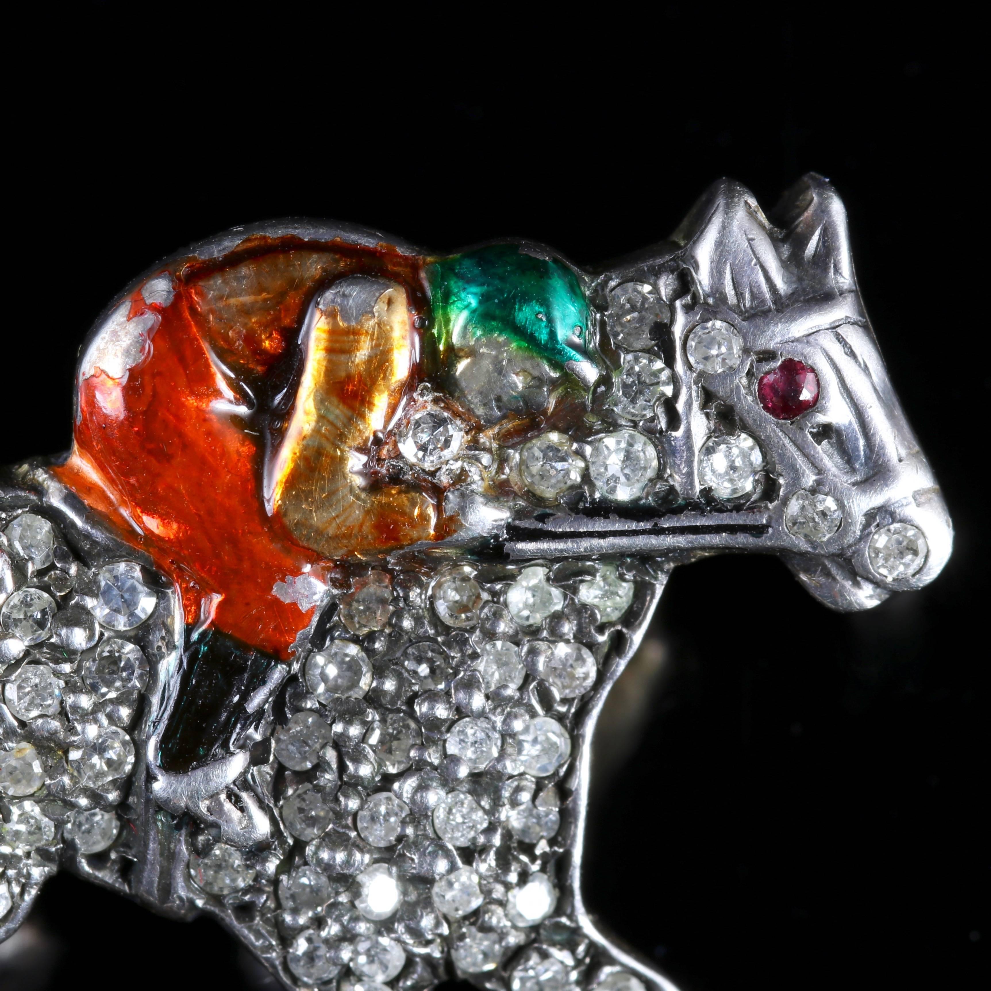 To read more please click continue reading below-

This fabulous antique Victorian brooch is adorned with Diamonds picturing a jockey on a speeding race horse.

Fabulous Enamel detail is displayed on the jockey with his red jodhpurs and green