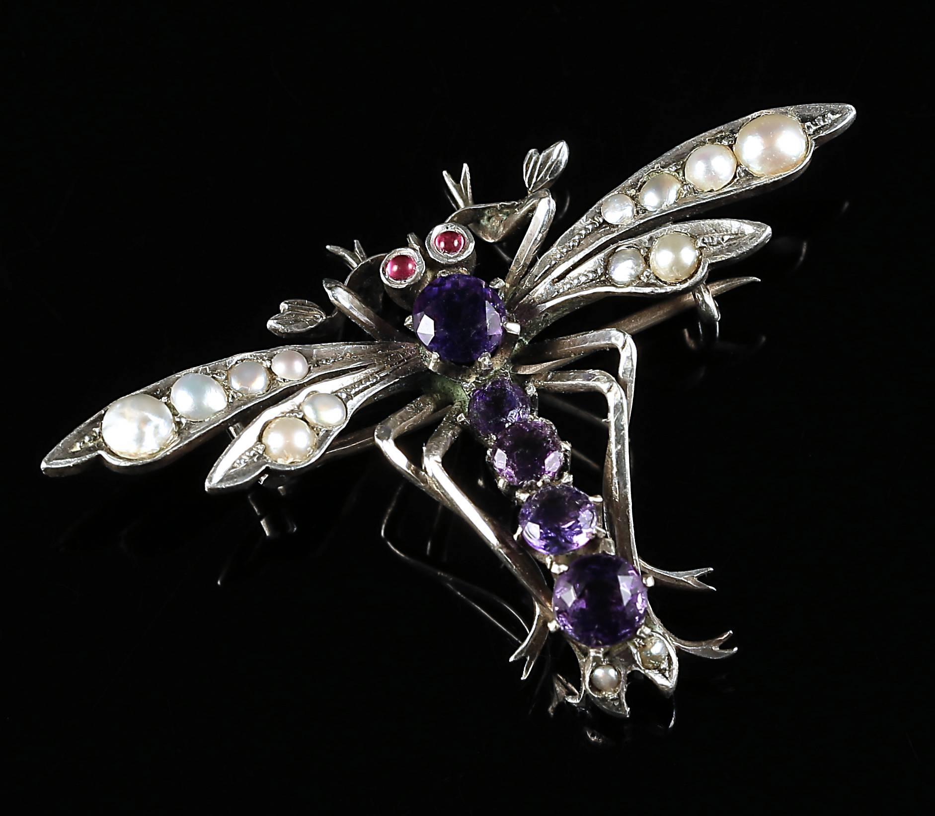 This genuine Victorian Antique Sterling Silver Dragon Fly brooch is set with beautiful pearls, rubies for his eyes and amethyst stones for his body.

The purple amethyst has been highly esteemed throughout the ages for its stunning beauty and