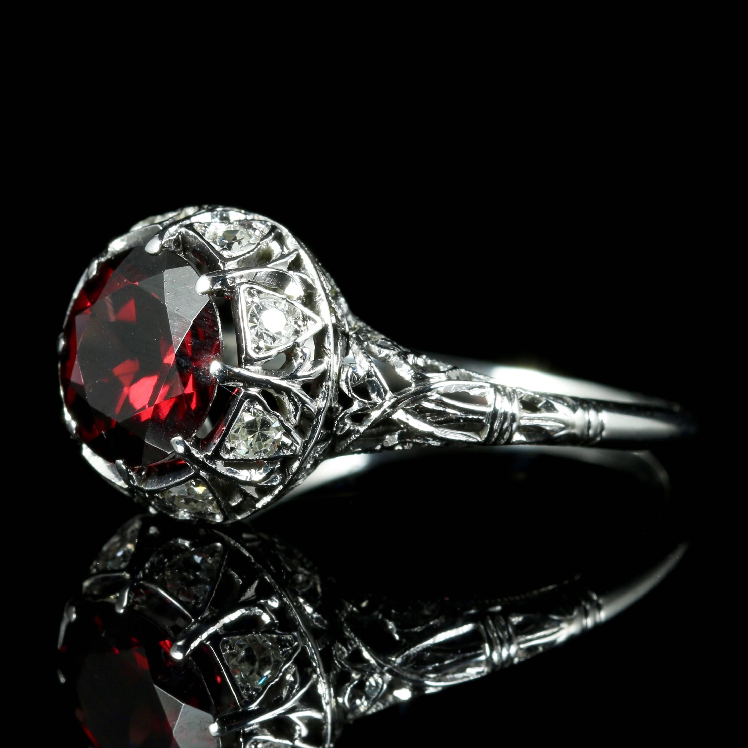 This fabulous Antique all platinum ring is Circa 1920.

Set with a deep red Garnet and old cut Diamonds which are set into the gallery of the ring.

The Antique ring has been tested as platinum.

The lovely deep red natural Garnet has a lovely red