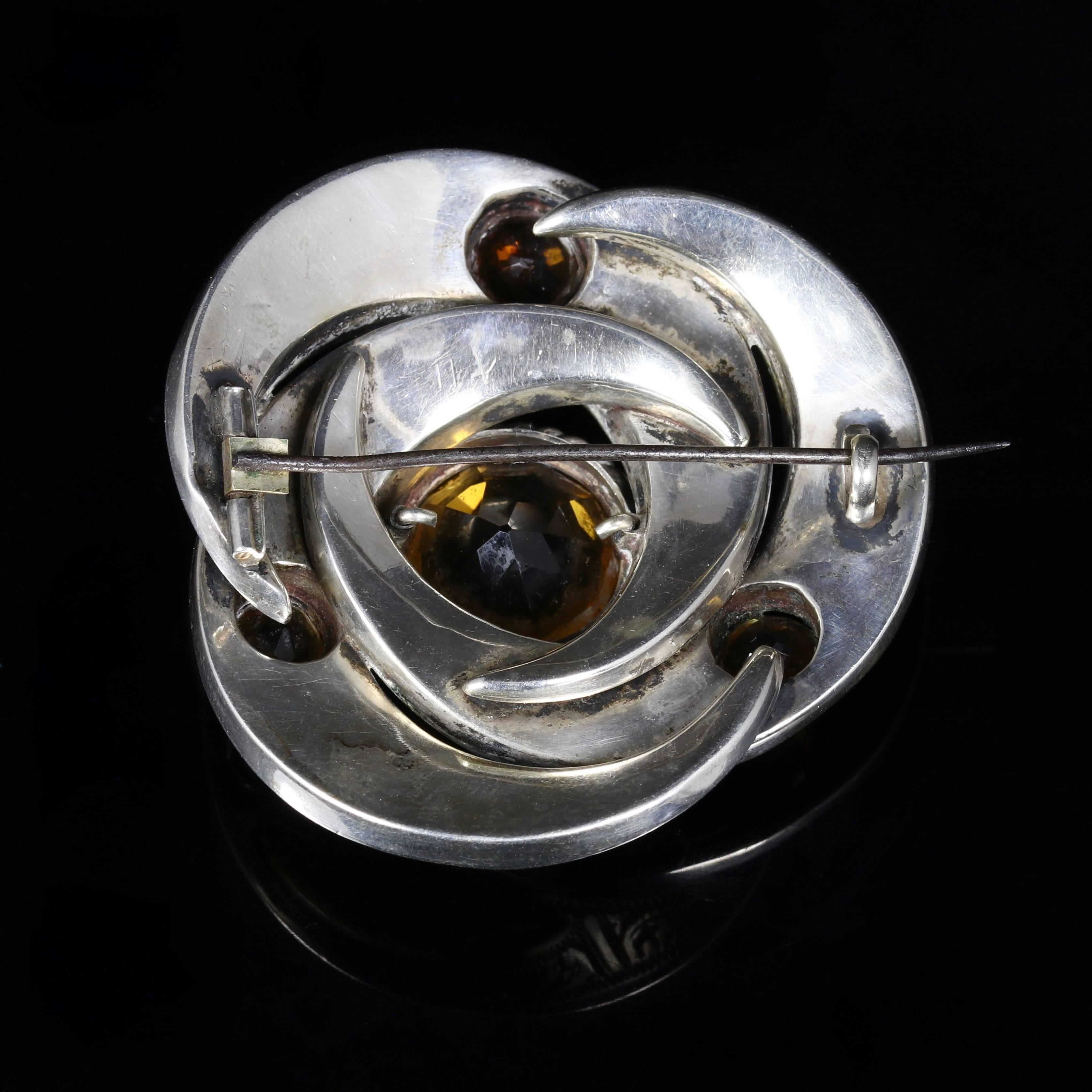 This is a fabulous large Sterling Silver Scottish Agate brooch.

Set with a beautiful Cairngorm in the centre complimented with smaller Cairngorms and polished Agates which are set into the Scottish Silver Agate Gallery.

The brooch is quite large