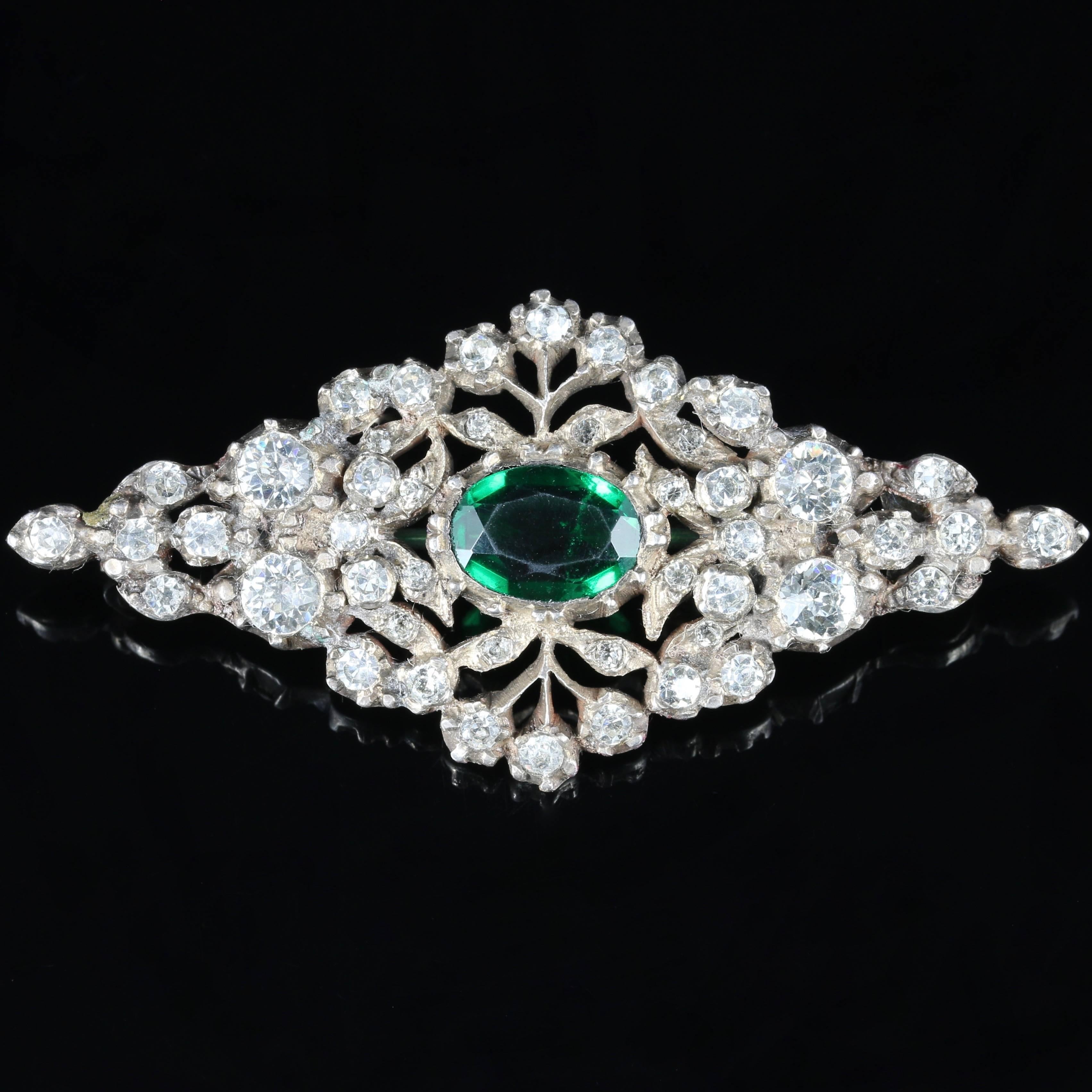 This beautiful  brooch  set with lovely bright white Paste stones which are foiled backed and a large green Paste stone in the centre.

All set in Sterling Silver.

The central green Paste stone is 3.80ct in size.

A Victorian safety catch has been