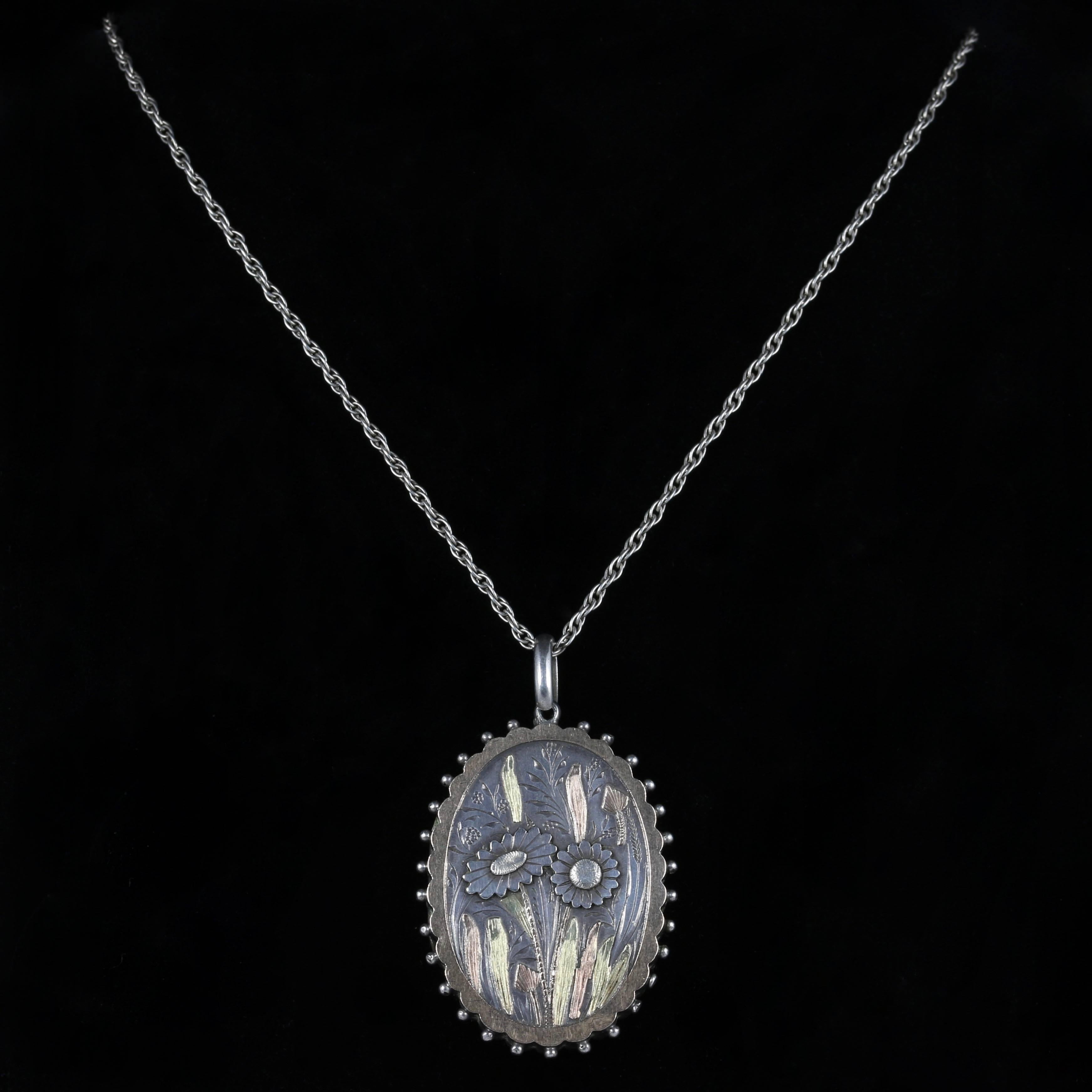 This beautiful Victorian Sterling Silver locket necklace is Circa 1900

The exquisite locket is set with two coloured Gold on the front, Rose Gold and 18ct Yellow Gold. 

A beautiful floral display sits on the front of the locket depicting two
