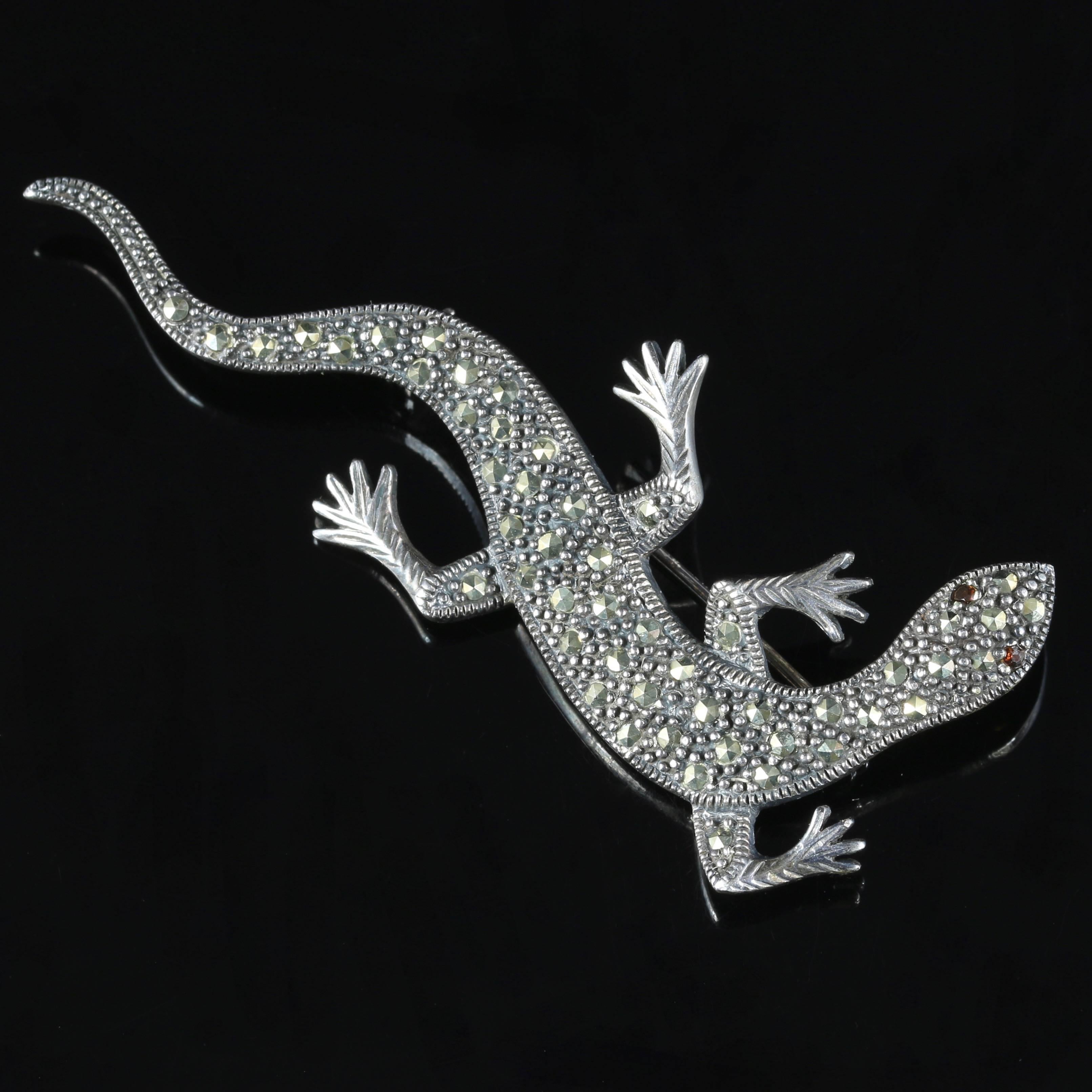 This fabulous antique Sterling Silver lizard brooch is Circa 1900

Set with Marcasites all over his body and Garnets for his eyes, this brooch is stunning. 

Marcasite jewellery has been made since the time of the Ancient Greeks. It was particularly