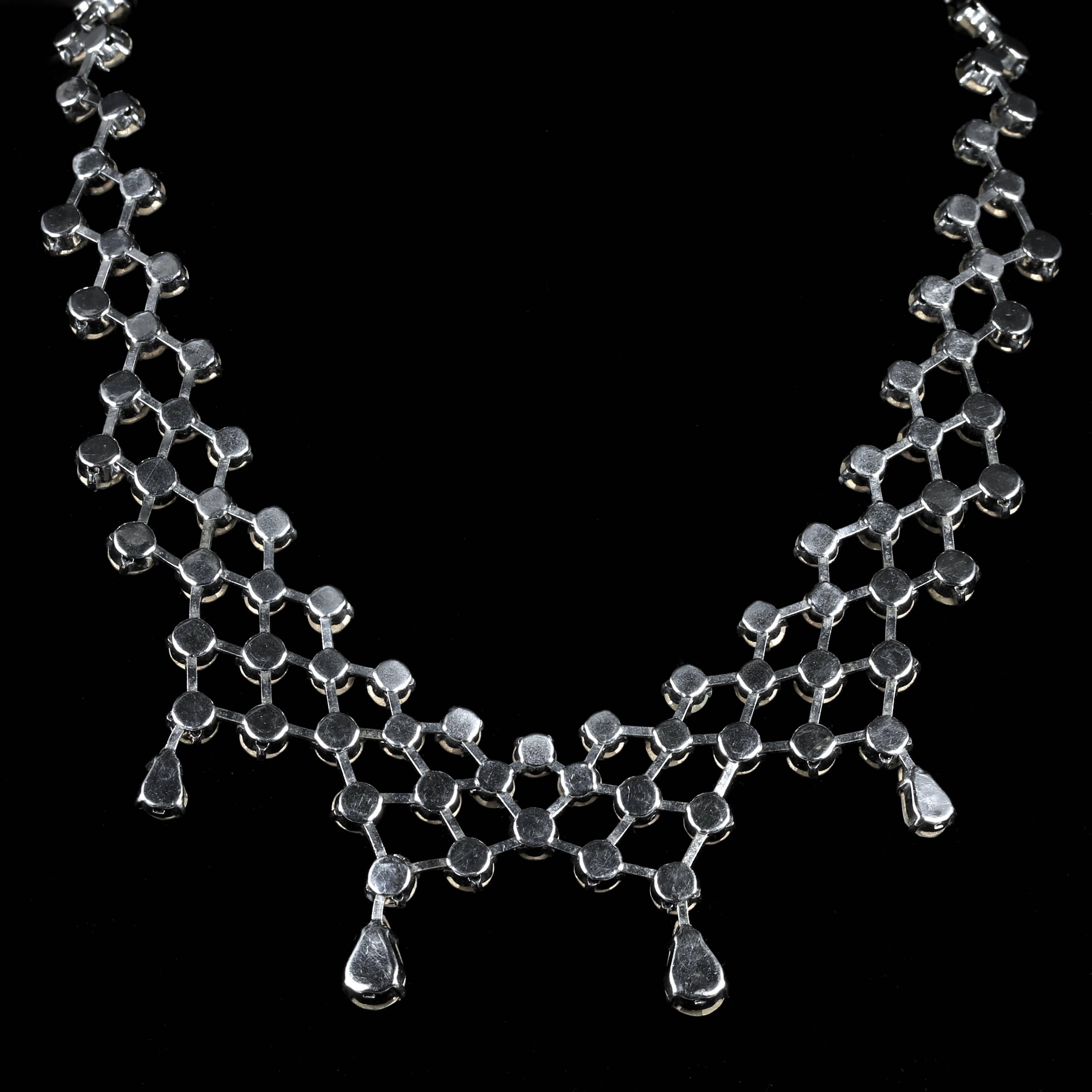 To read more please click continue reading below...

This fabulous 1920's Garland Paste necklace is simply beautiful.

Set with sparkling bright White Paste Stones which adorn the neck when worn.

Paste is a heavy, very transparent flint glass that