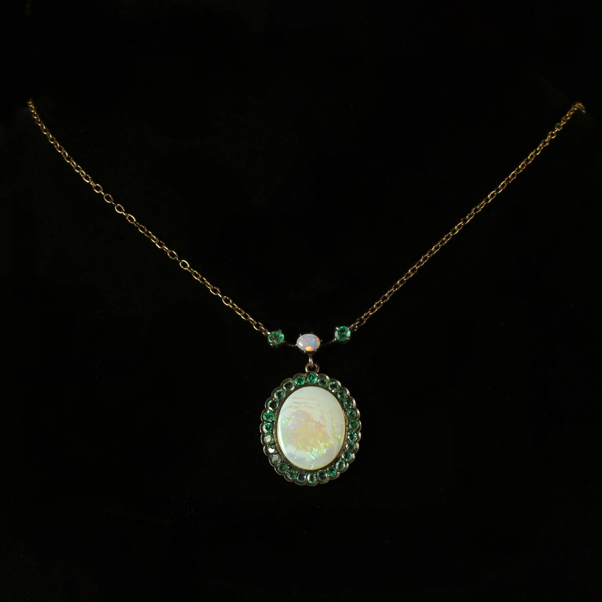 This beautiful 9ct Gold Opal and Emerald necklace is Circa 1900.

The wonderful necklace is adorned with an Opal which is just under 0.25ct with two other small Emeralds either side which are both 0.10ct each.

This leads to a large Opal dropper