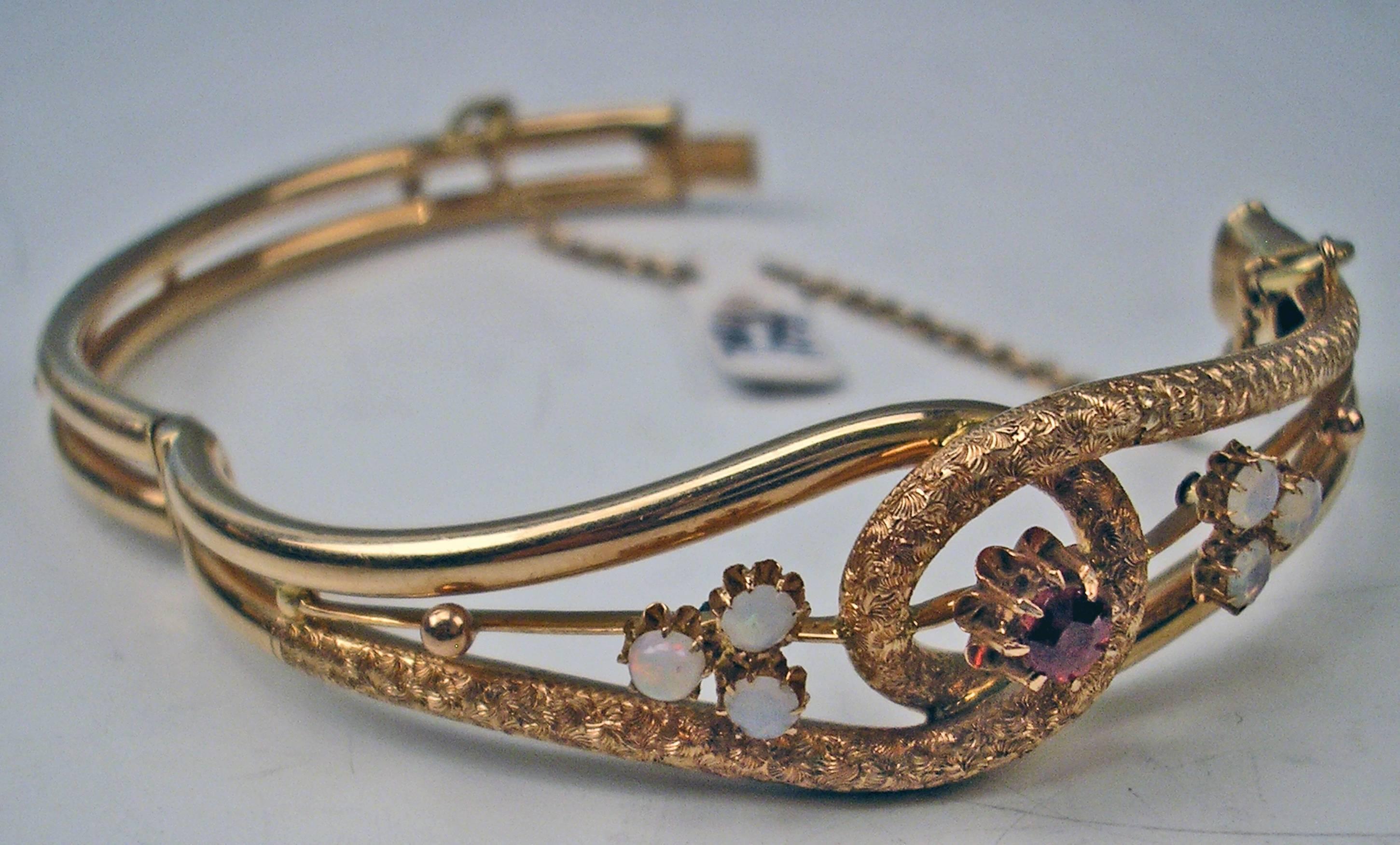 Most elegant ART NOUVEAU golden bangle with SIX OPALS as well as ONE ALMANDINE attached to middle part. Secure chain at closure existing.

GOLD  (14 CARAT GOLD / 585) 

Total weight:  13 grams     0.458 oz

Hallmarked:
Austrian Official Punch