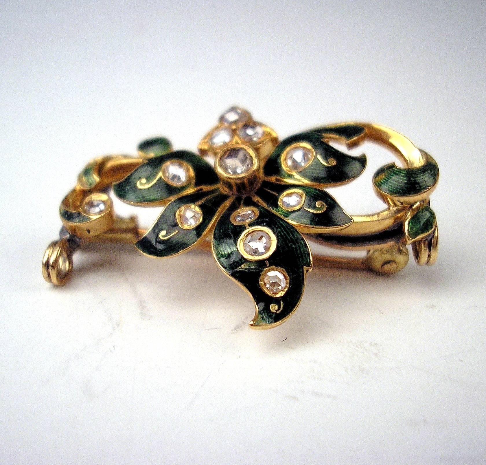 Art Nouveau Brooch
Vienna, made c. 1900
14 Carat Gold  /  585   (checked)
Yellow Gold, covered with enamel as well as with many small diamonds (vintage cuts  /  circa 0.40 carat in total). - The brooch is shaped in floral form type   ( = scrolls
