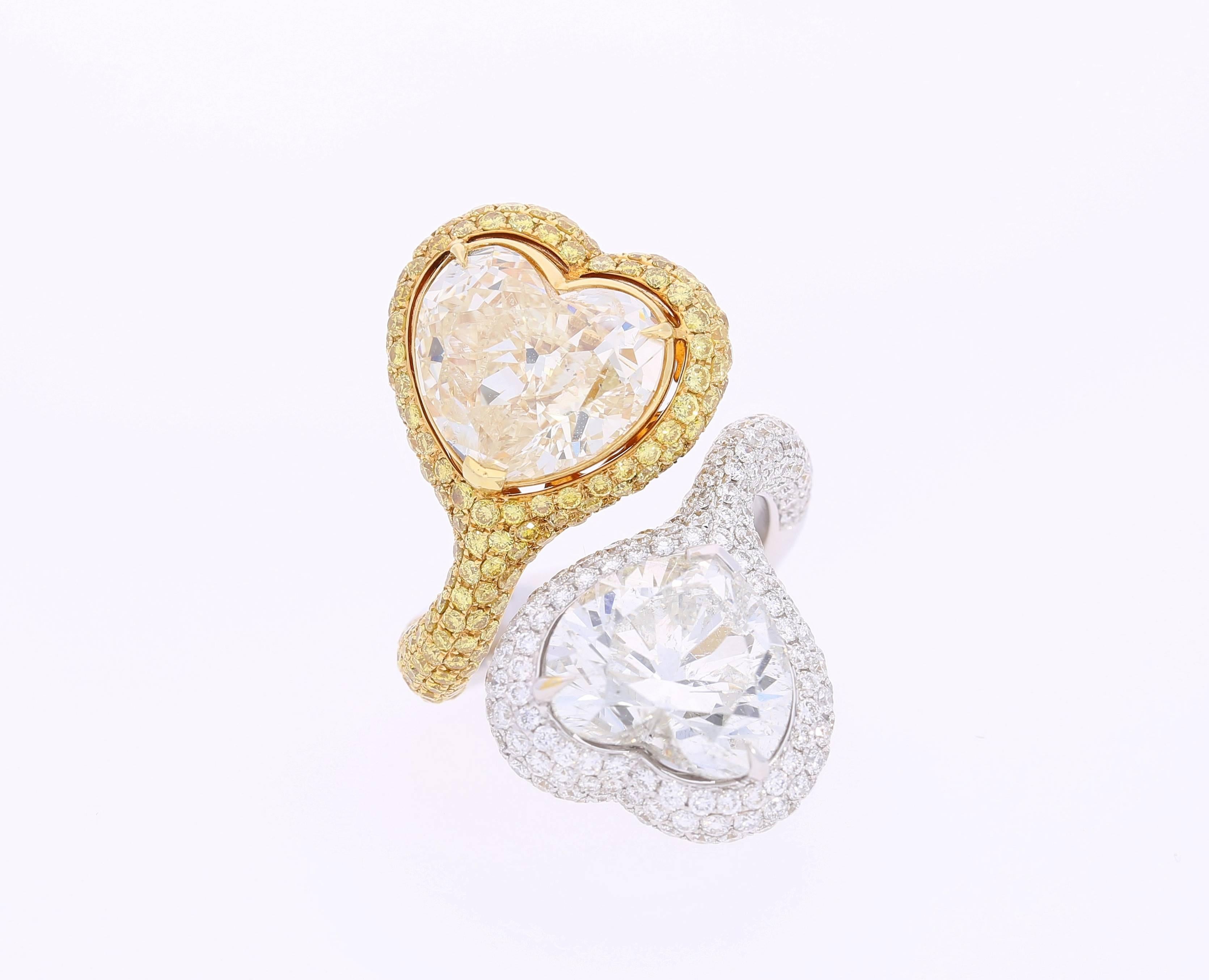 Centering a pair of heart-shape diamonds. The White is a 5.79 carat, G color, SI2 Clarity diamond. The Yellow is Fancy Light Yellow color, 5.73 carats, SI2 clarity. Both are certified by the European Gemological Laboratory. 

Total carat weight-