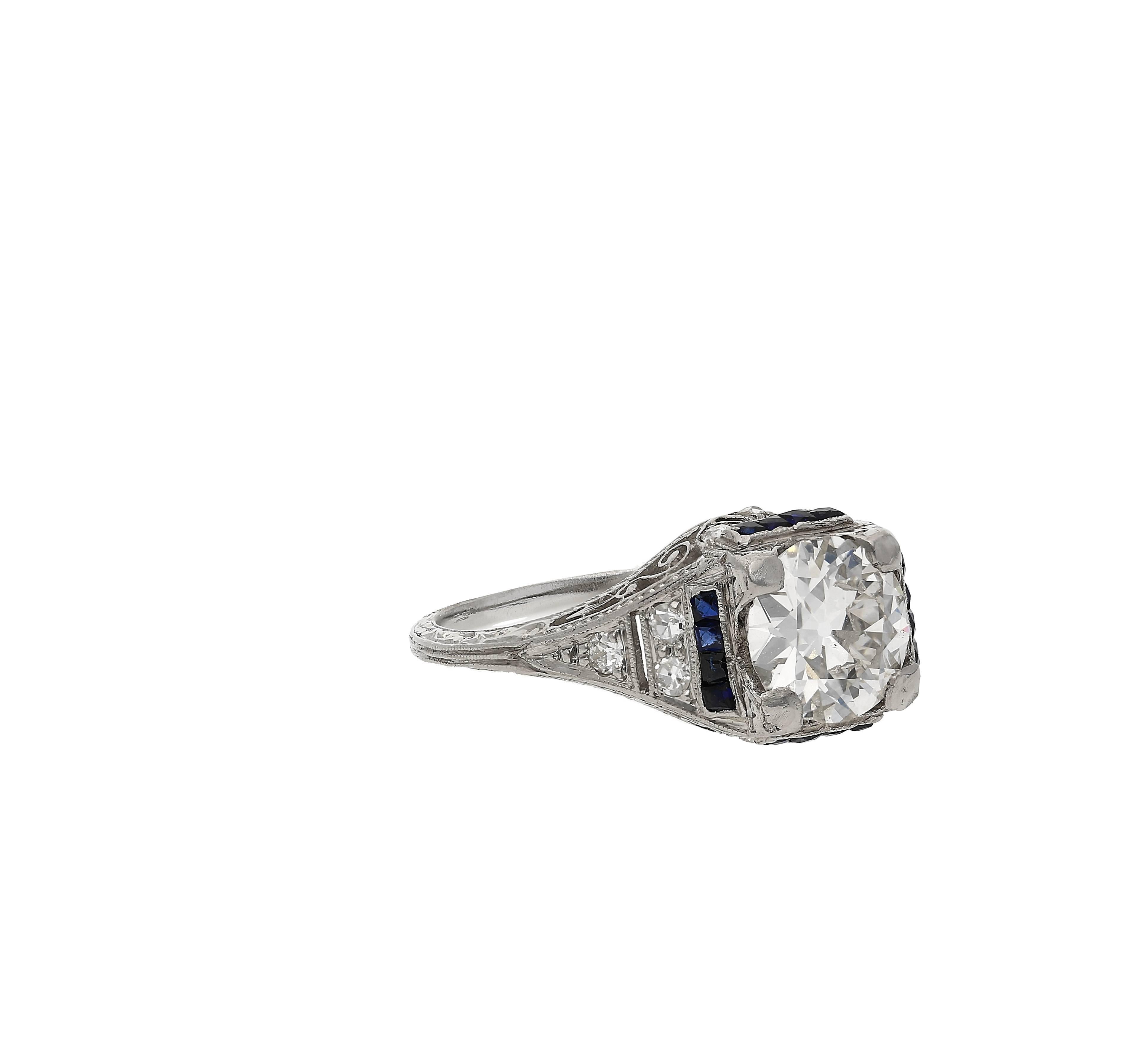 Centre-Stone weighs approximately 1.28 Carats
Set in PT900 Platinum
Accented by 12 Round-Brilliant Cut Diamonds and 16 Emerald-Cut Synthetic Sapphires
