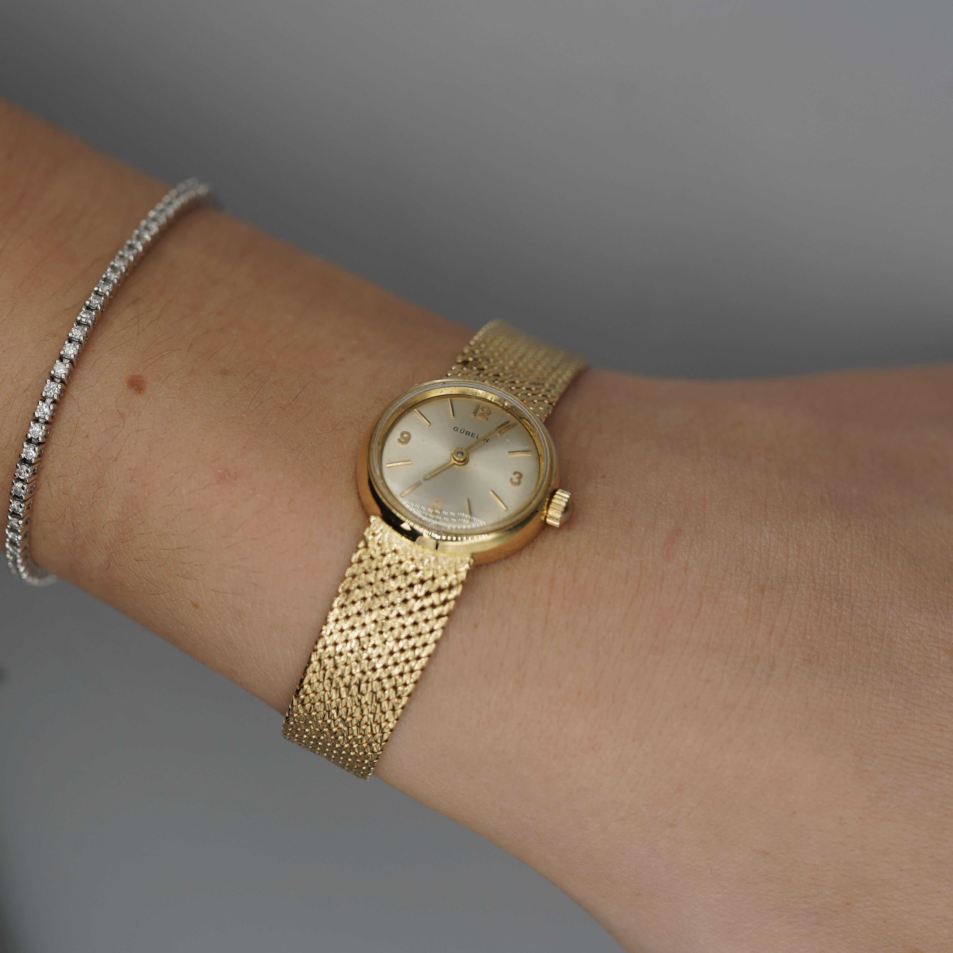 Un raffinato orologio da polso vintage da donna di Gübelin, che mette in mostra l'intramontabile maestria svizzera in una calda struttura in oro giallo 18 carati. Progettato con un quadrante color champagne e un delicato bracciale a maglie, questo
