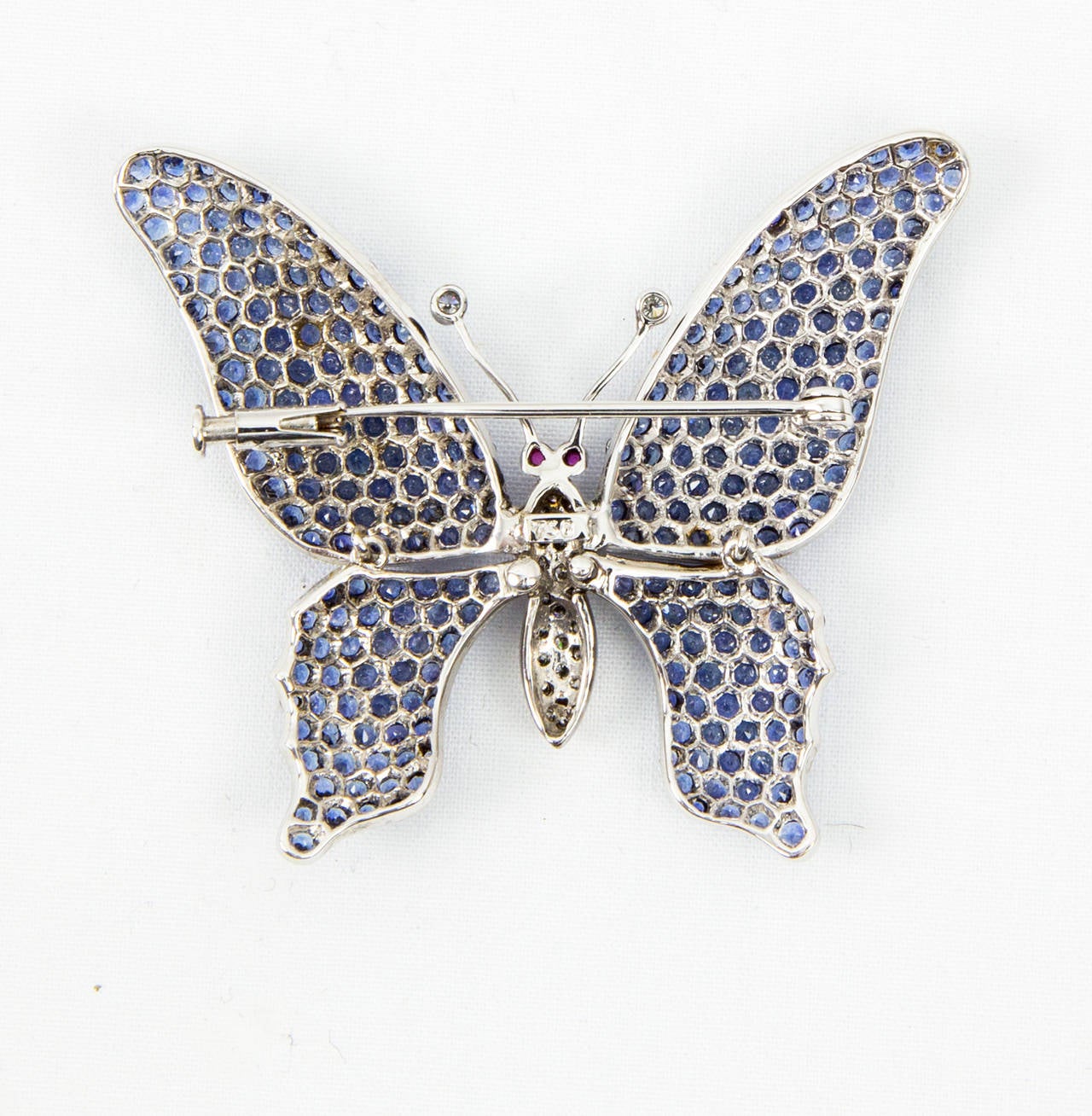 Beautiful Blue Sapphire and Diamond Butterfly; micro-set with diamond-cut sapphires, body and antennae set with brilliant-cut diamonds, eyes set with pink cabochon sapphires. Handmade in 18k white gold; tremblant wings ; marked on back: 750