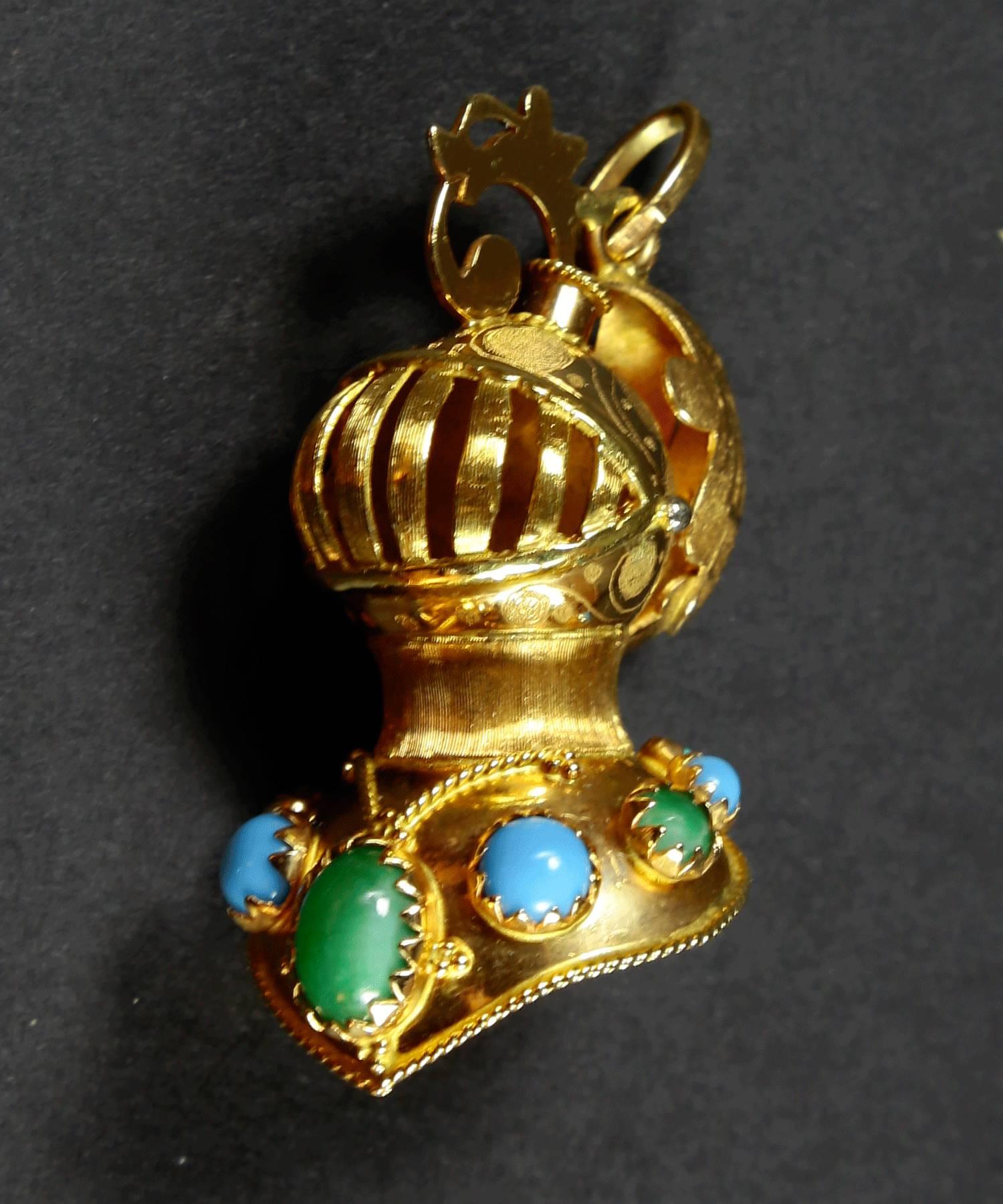  Full Helmet Gold Charm Pendant set with Turquoise stones; hand chased and crafted in 18k yellow gold; marked: 18K AR; measuring approx. 1.5” high.
