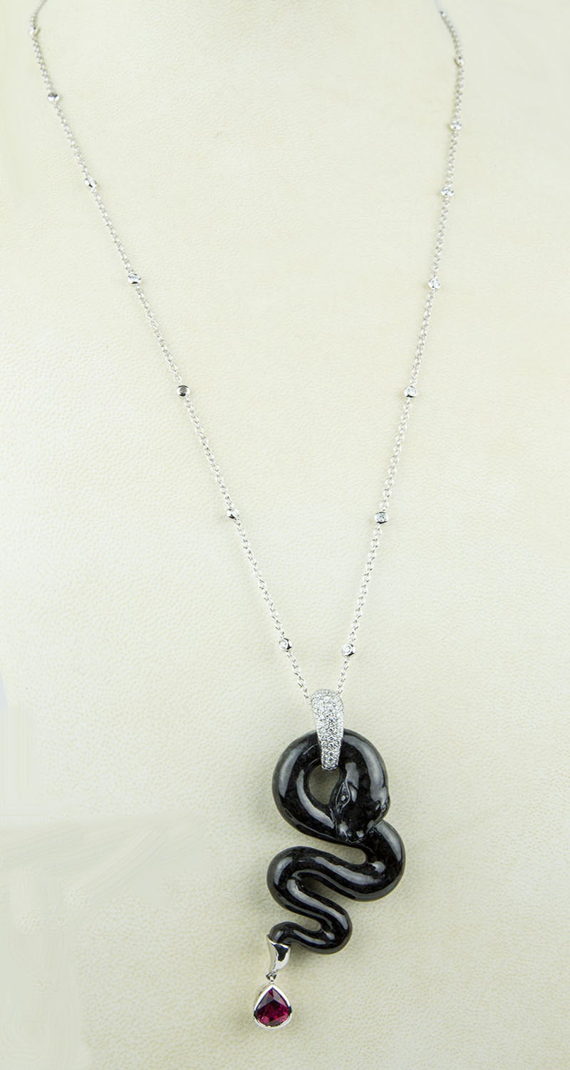 Sensational Drop Necklace featuring a Black Carved Jade Snake Pendant suspending a Teardrop Rubelite, Micro-set Diamond bale; suspended on a 14k chain inter-spaced with round cut Diamonds in tube settings; hand crafted; Approx Weights: 18k pendant