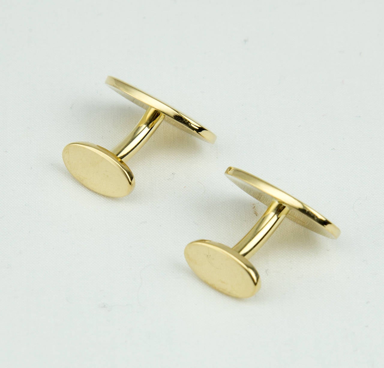 Classic Tiffany & Co. Cufflinks; polished oval shapes with push-through ovals; crafted in 18K yellow gold; marked: TIFFANY & CO. 750. approx. dimensions: 19.5mm x 13.5mm; approx. total weight: 14.4gm. C1960s Sophisticated & Stylish!