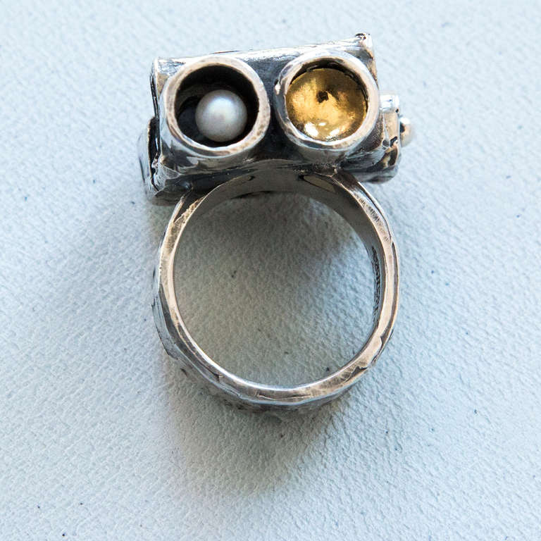 Unique Walter Schluep Sterling Silver Garnet Pearl Gold Ring; rectangular tubular form housing pearls and gold enhancements; all handmade and hand hammered; top set with two round facet-cut garnets; top of ring measures approx. 25mm x 24mm; approx.