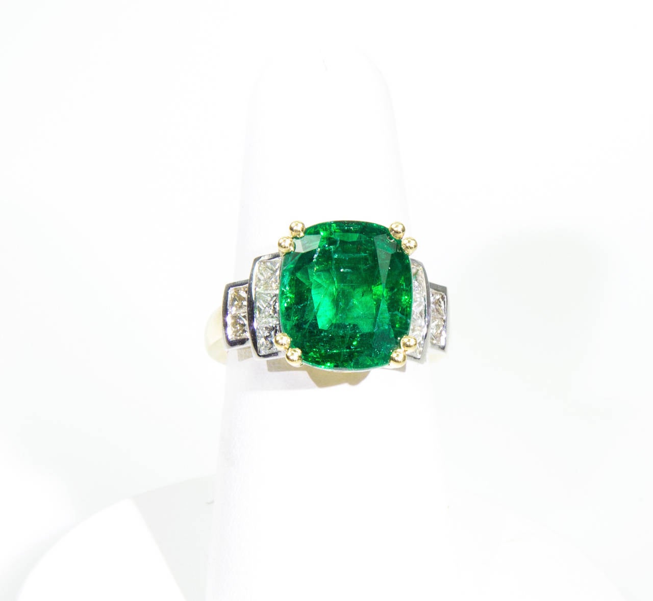 Featuring a Fabulous 7.60ct Cushion-cut Emerald Ring, accented on shoulders with a total of ten square-cut diamonds; in beautifully hand crafted 18k yellow gold mounting; approx. 0.08ct x 10 diamonds=approx 0.80ct; clarity SI1; color H/I; approx.