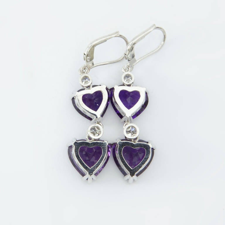Simply Beautiful!  Diamond Hearts Gold Dangle Earrings. Each earring features two facet-cut Amethyst inter-spaced with two round Brilliant cut Diamonds. Hand crafted in hand made 14k Gold setting. Measuring approx. 2” long. Approx. total weights of
