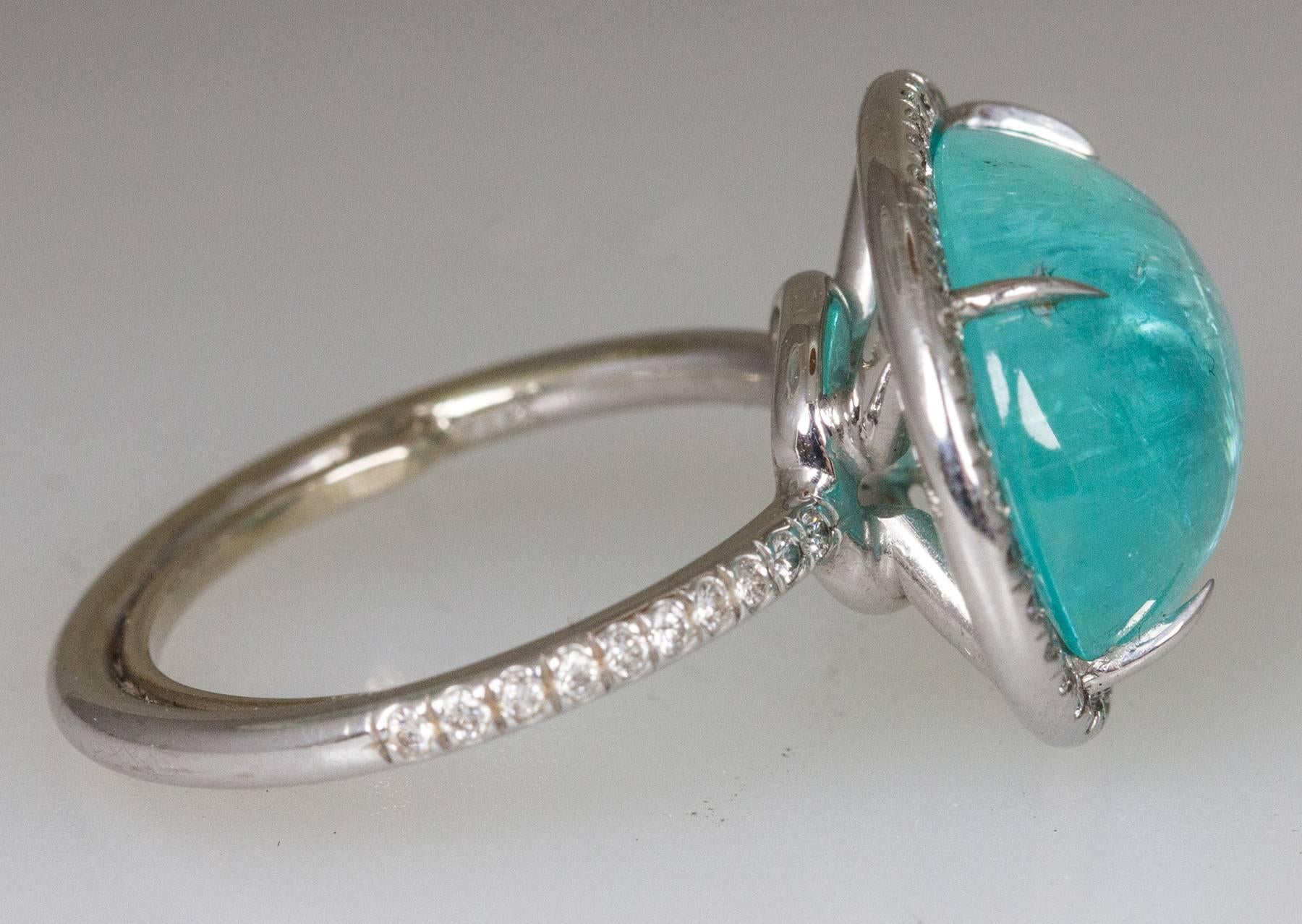 Centering a Beautiful Neon Blue Green 8.95ct oval Paraiba Tourmaline from Brazil; measuring approx. 15.4mm x 12.4mm surrounded by round brilliant cut diamonds, 0.45tctw; Ring size: 6. Complimentary ring sizing available. Classic and Timeless, taking