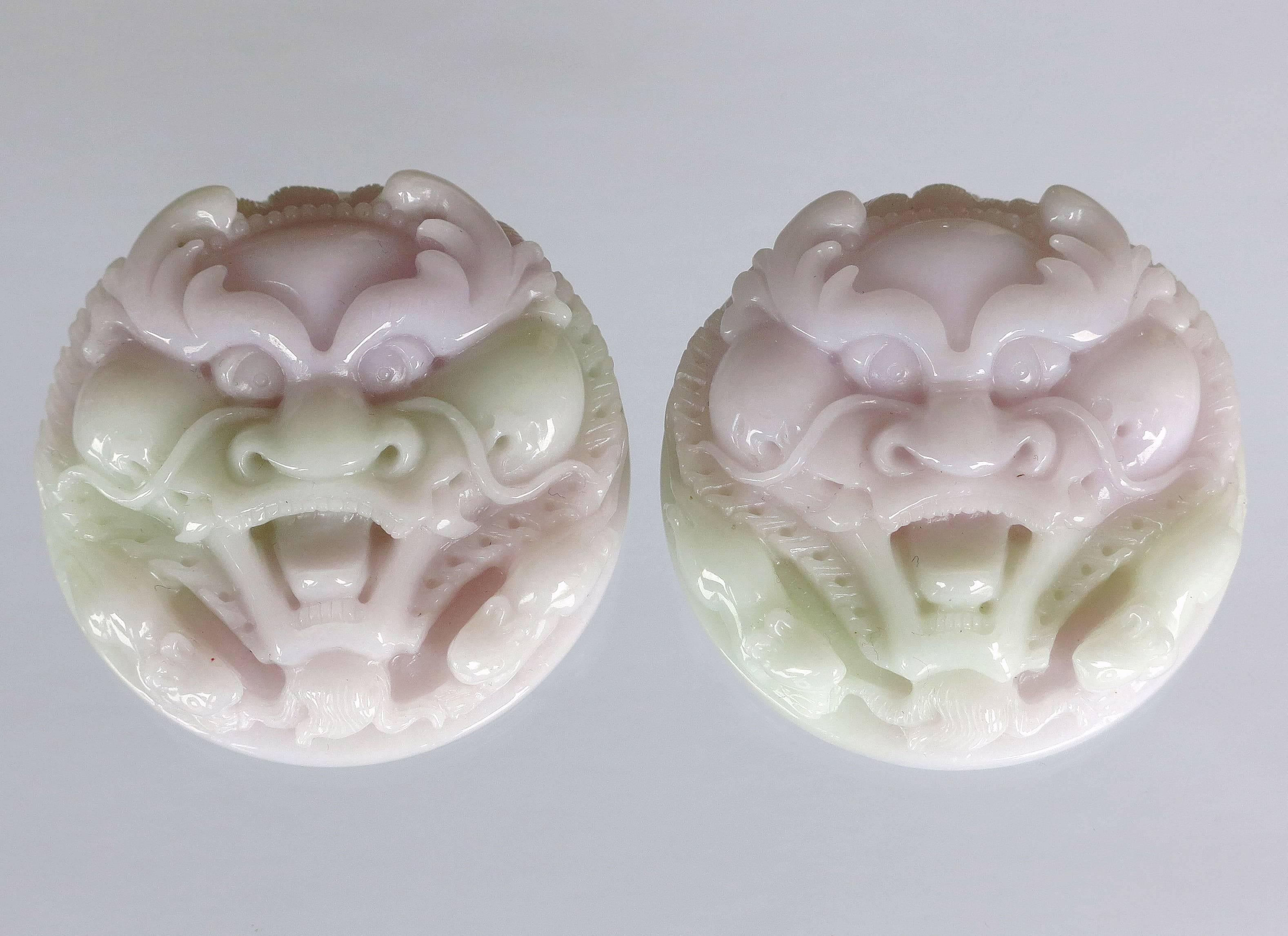 Beautiful pair of Hand Carved Jadeite Masks. Light lavender and very light mint-green. Each has a diameter of 56 mm. Average thickness is 20 mm. Total weight of the pair is 226 grams. Ideal for mounting in a Shadow Box Frame or set on top of a Box.