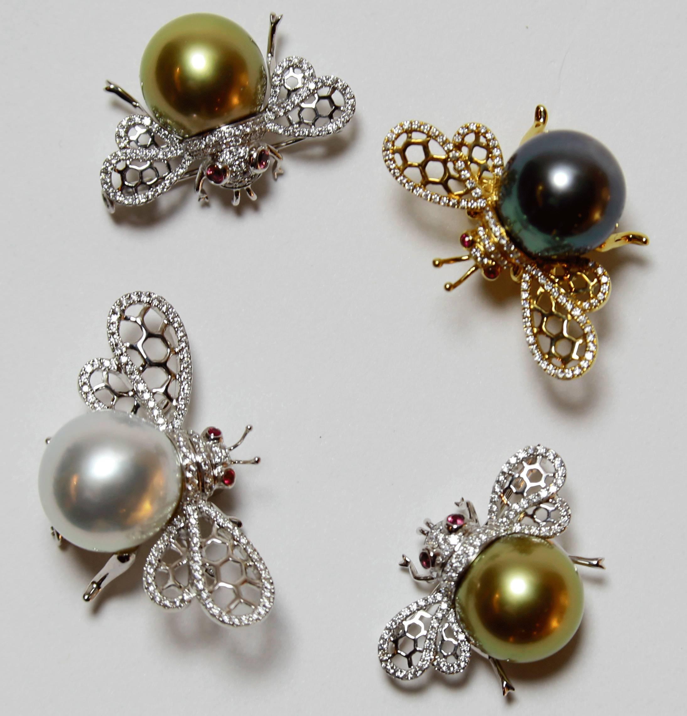 Beautiful Bumble Bee pin, set with approximately 0.34ctw in G/VS diamonds, enhancing the wings and body, a 14mm Tahitian Black South Sea Pearl and two Ruby eyes; 18k yellow gold; pin measures approx. 34.3mm x 23.7mm and weighs approx. 11.30 gm. A