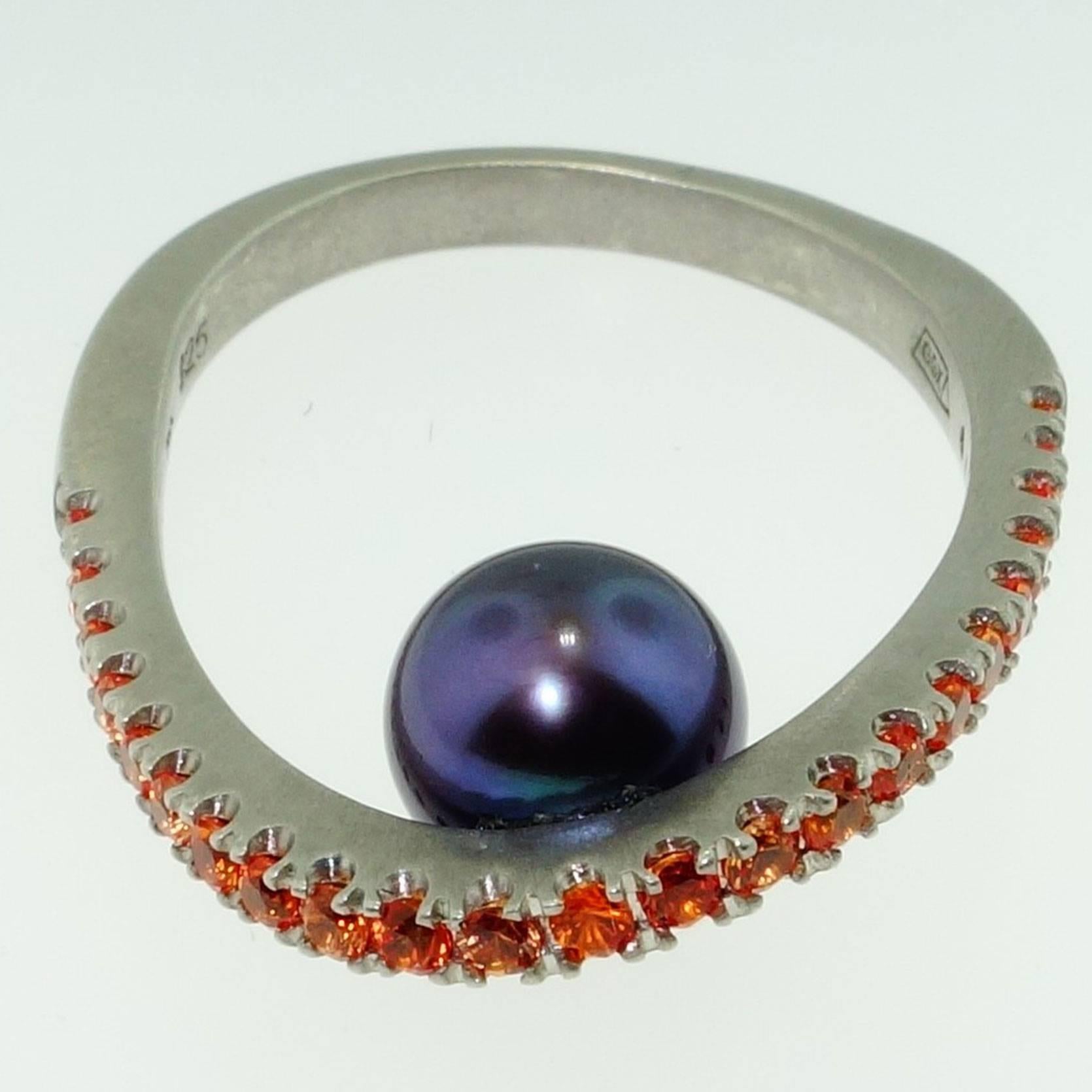 Featuring a Black freshwater Pearl below held by a 14K post; top of Runway ring enhanced with Orange Sapphires; approx.  .70tctw; Sterling Silver Tarnish-resistant Rhodium mounting; Size 7; we offer complimentary ring re-sizing. More fabulous in