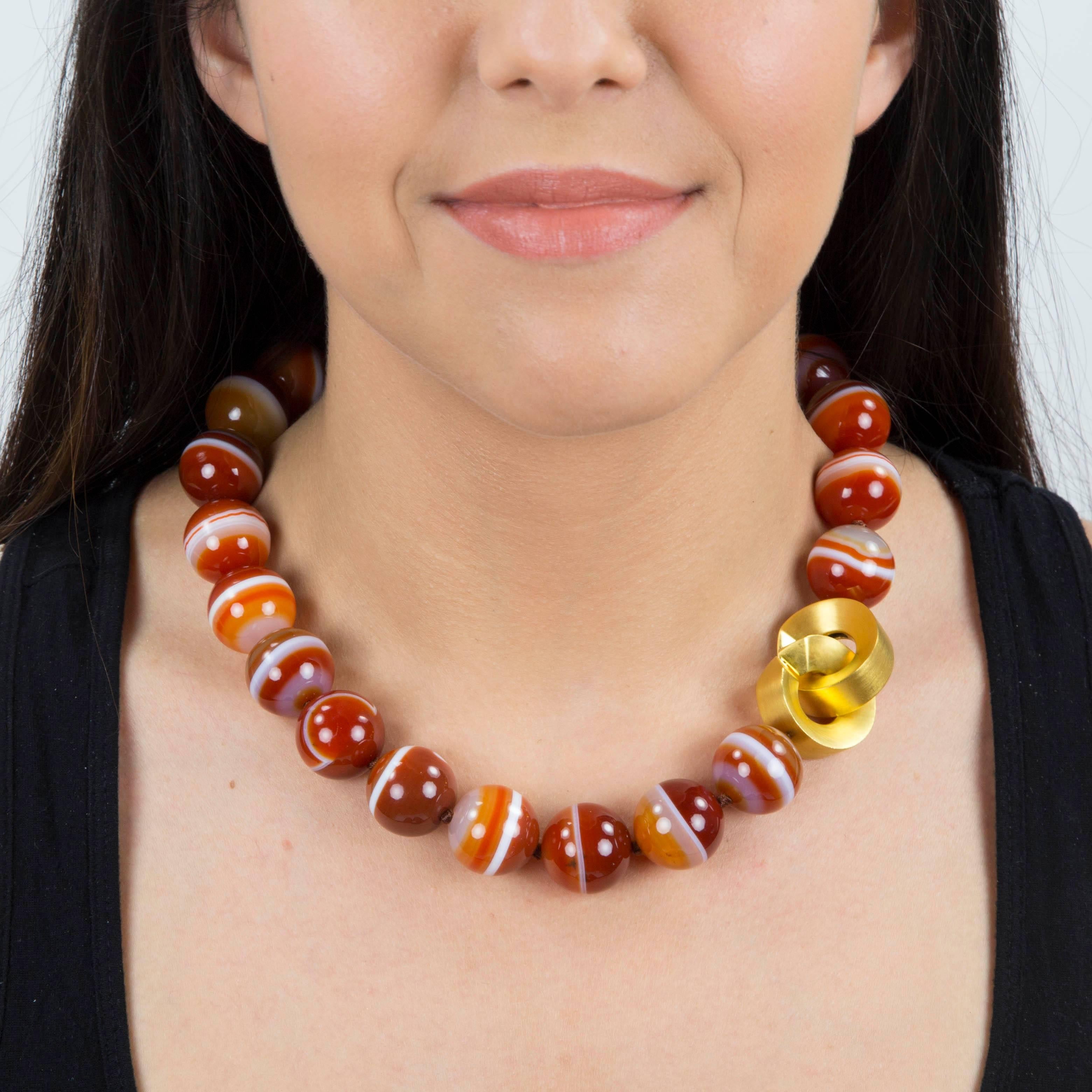 Stunning Large Carnelian Banded Agate Bead Necklace comprising twenty-four 19.55mm beads; held by a unique bold Gilt Sterling Silver clasp; newly hand knotted with Silk cord. Stylish and Dynamic…illuminating your look with Timeless Beauty!   
