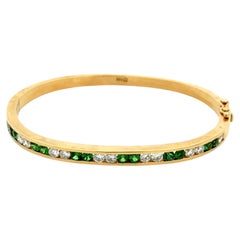 Bracciale rigido in oro con incastonatura a canale alternata di diamanti e tsavoriti, di alta qualità, di seconda mano