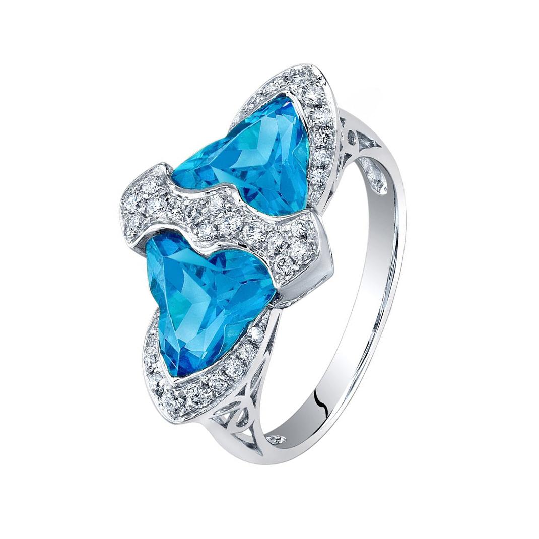 Beautiful Blue Topaz ring surrounded by 37 brilliant-cut round Diamonds, weighing approx. 0.60 ct.facet-cut Blue Topaz; beautifully crafted in 14k white gold with open gallery. Ring size: 7. *Complimentary re-sizing available. Timeless Chic,