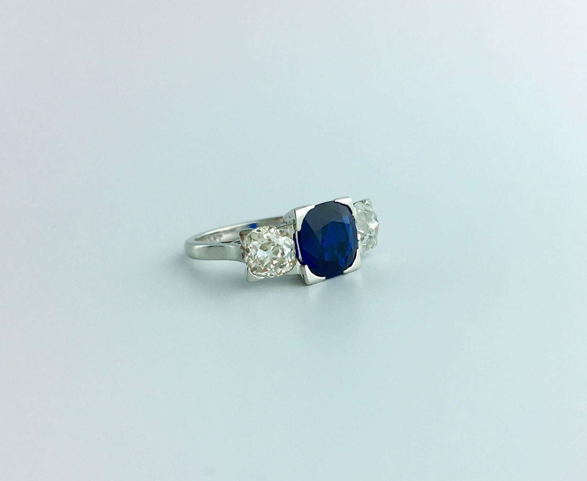 Elegant Natural Blue Sapphire weighting approximately 2.00 carats sided by two Old mine cut Diamonds (approximately 1.00 carat) mounted on platinum.
Circa 1920.

Gross weight: 5.69 grams